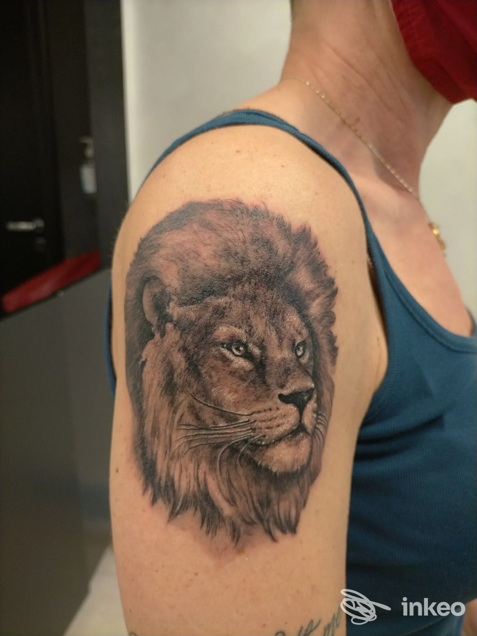 Tatuaggio realistico di leone sull'omero realizzato da Generazione Tattoo a Rionero In Vulture, dettaglio in bianco e nero.