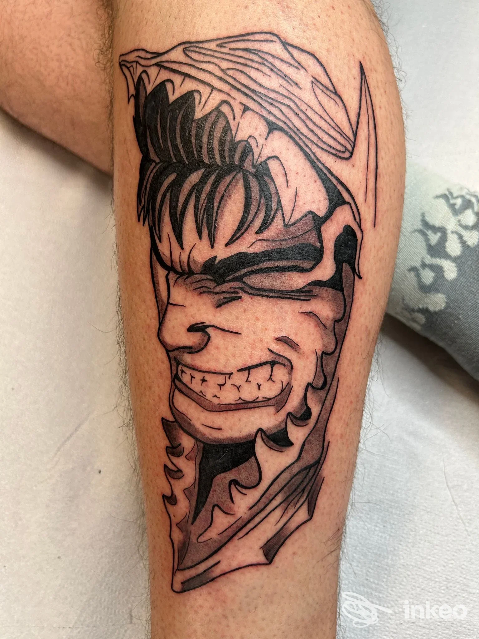 Tatuaggio in bianco e nero su polpaccio: volto stilizzato/maschera. Linea Nera Tattoo & Piercing - Trucco Permanente, Torino.