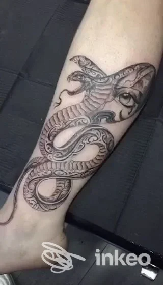 Tatuaggio di serpente in bianco e nero sull'arto inferiore, foto caricata da Linea Nera Tattoo & Piercing, Torino.