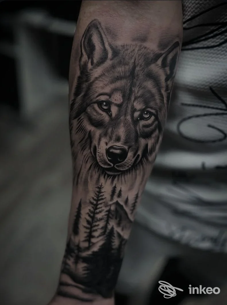 Tatuaggio in bianco e nero a tema lupo e foresta sull'avambraccio, Ordine sparso Tattoo e Trucco permanente di Federica Obinu, Orbassano.