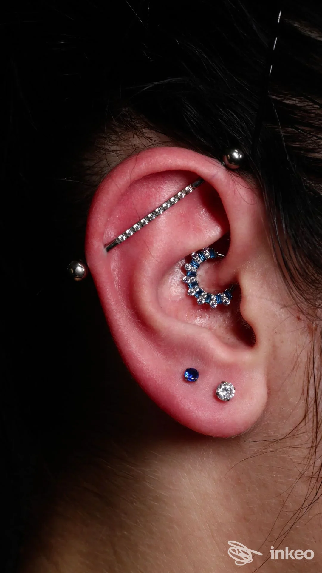 Primo piano di un orecchio con multipli piercing gioiello. Artemisia Luxury Body Piercing & Tattoo, Torino.