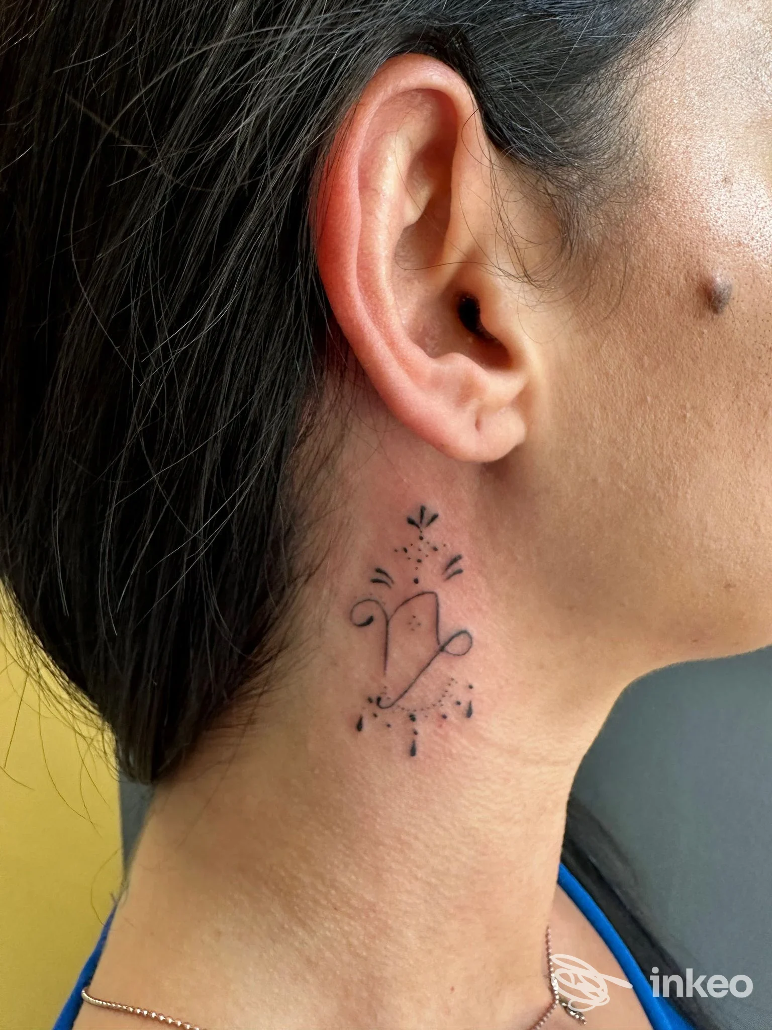 Piccolo tatuaggio nero stilizzato sul collo, foto di Taryn Chiereghin Tattoo & Pmu a Sant'Antonino di Susa.