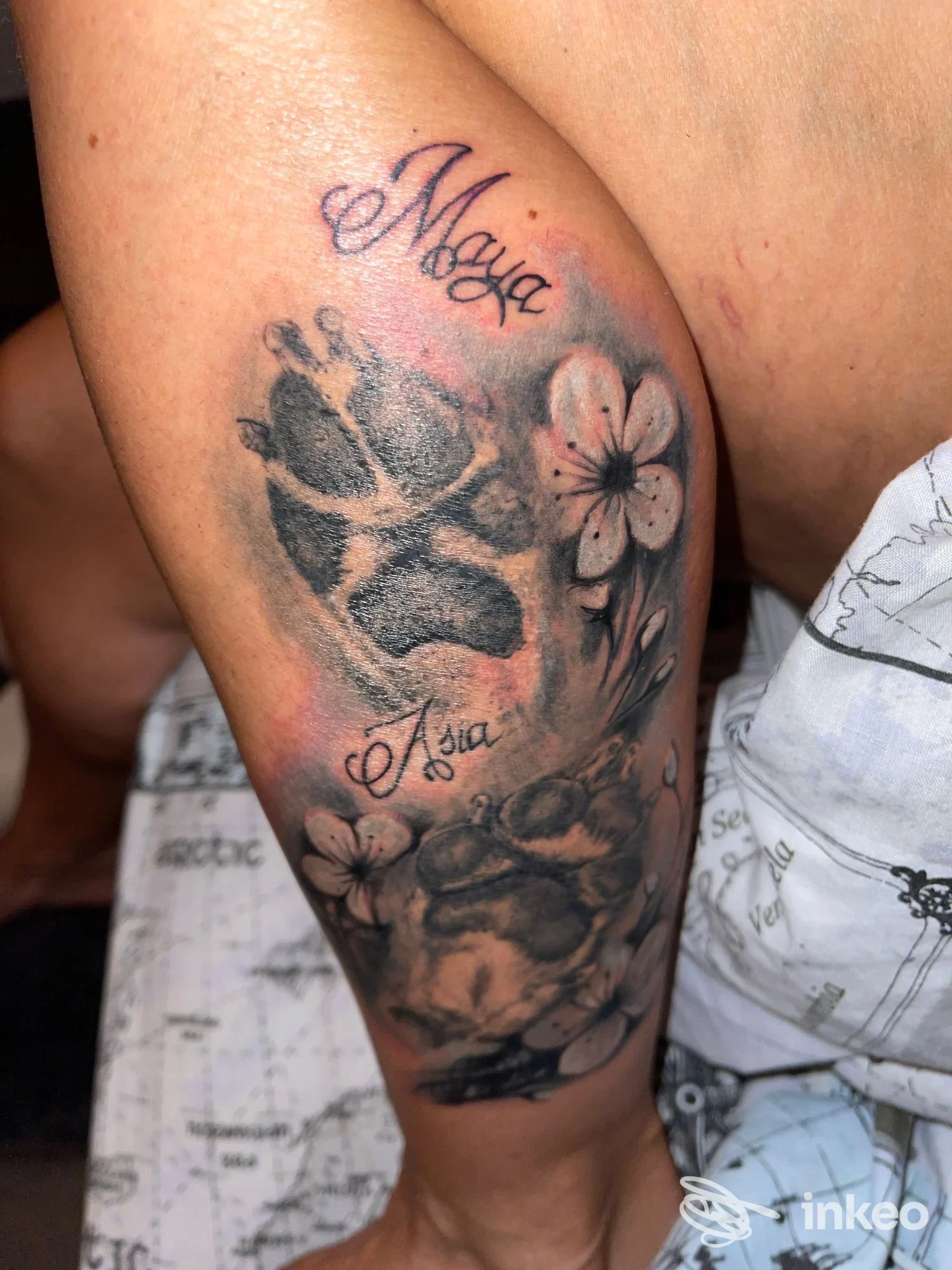 Tatuaggio black & grey su coscia con fiori e impronta, realizzato da Trio Tattoo, Torino.