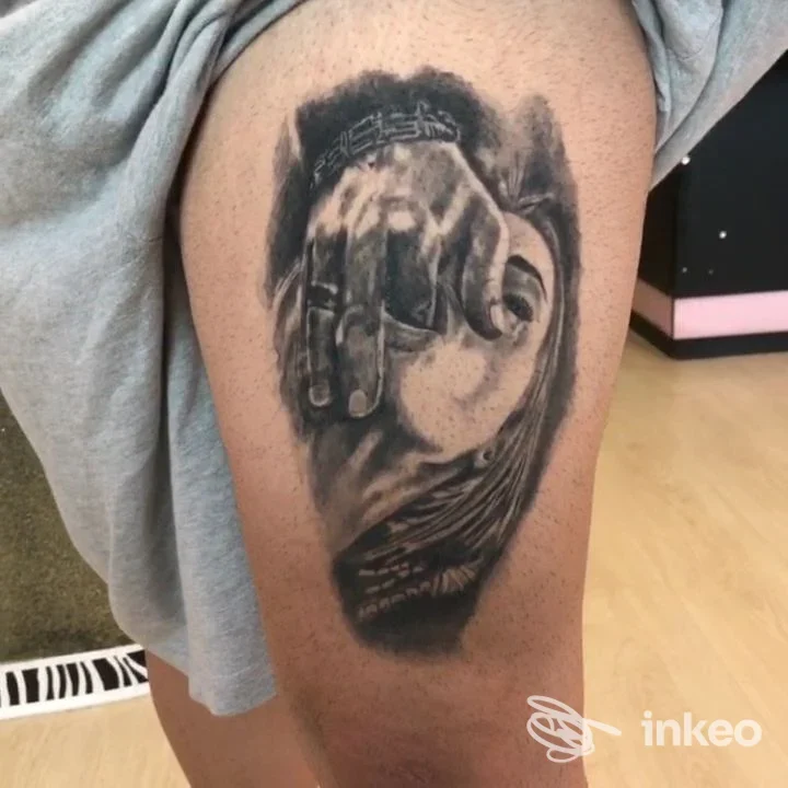 Tatuaggio realistico black & grey su coscia, mano che copre un volto. Venere Ink Tattoo, Torino.