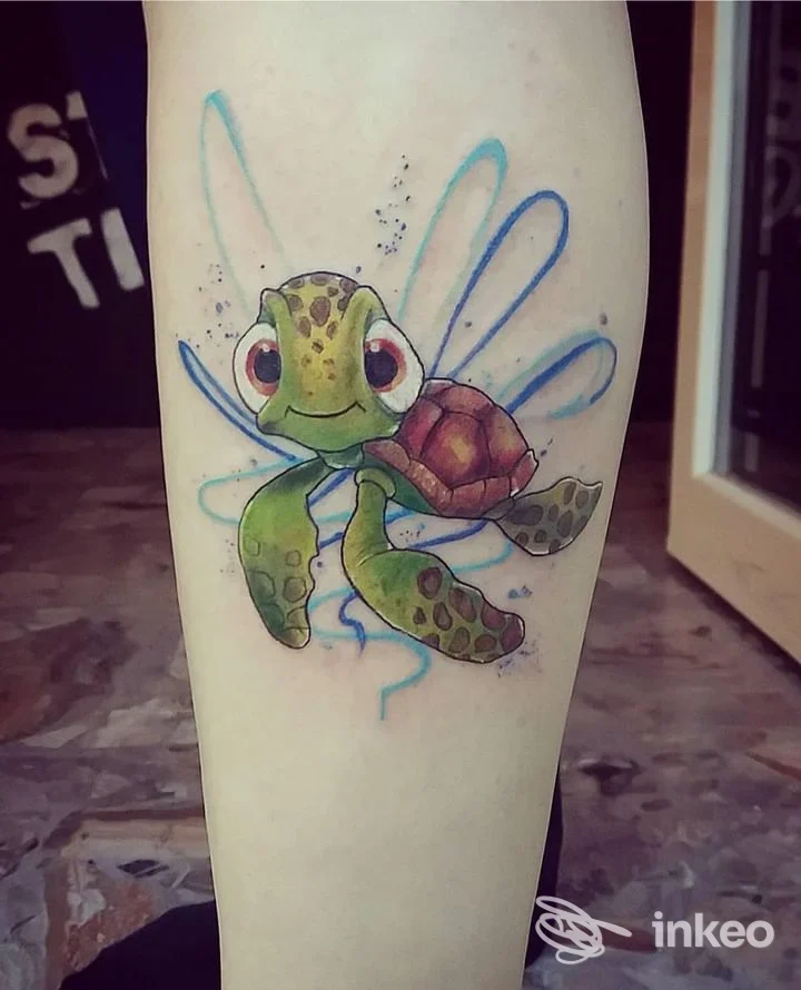 Tattoo colorato raffigurante una tartaruga verde con ali azzurre sulla gamba.