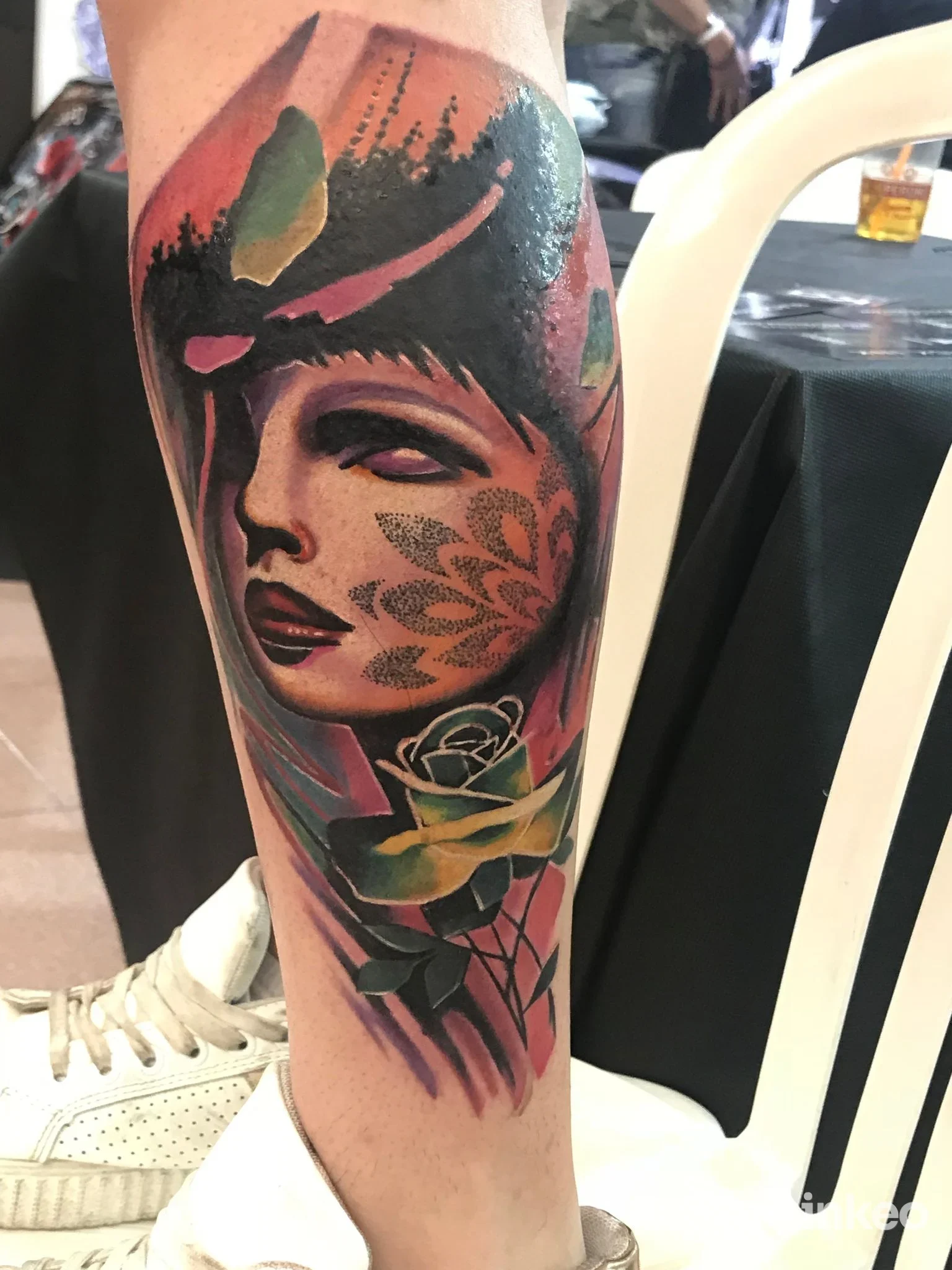 Tatuaggio colorato sul polpaccio con volto stilizzato e rosa — INK TATTOOs Capo d'Orlando, Capo d'Orlando.