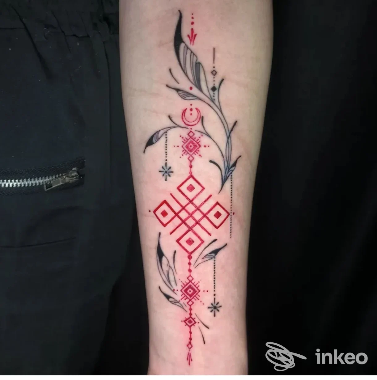 Tatuaggio geometrico rosso e nero sull'avambraccio, realizzato da Tattoo Skull studio a Catania.