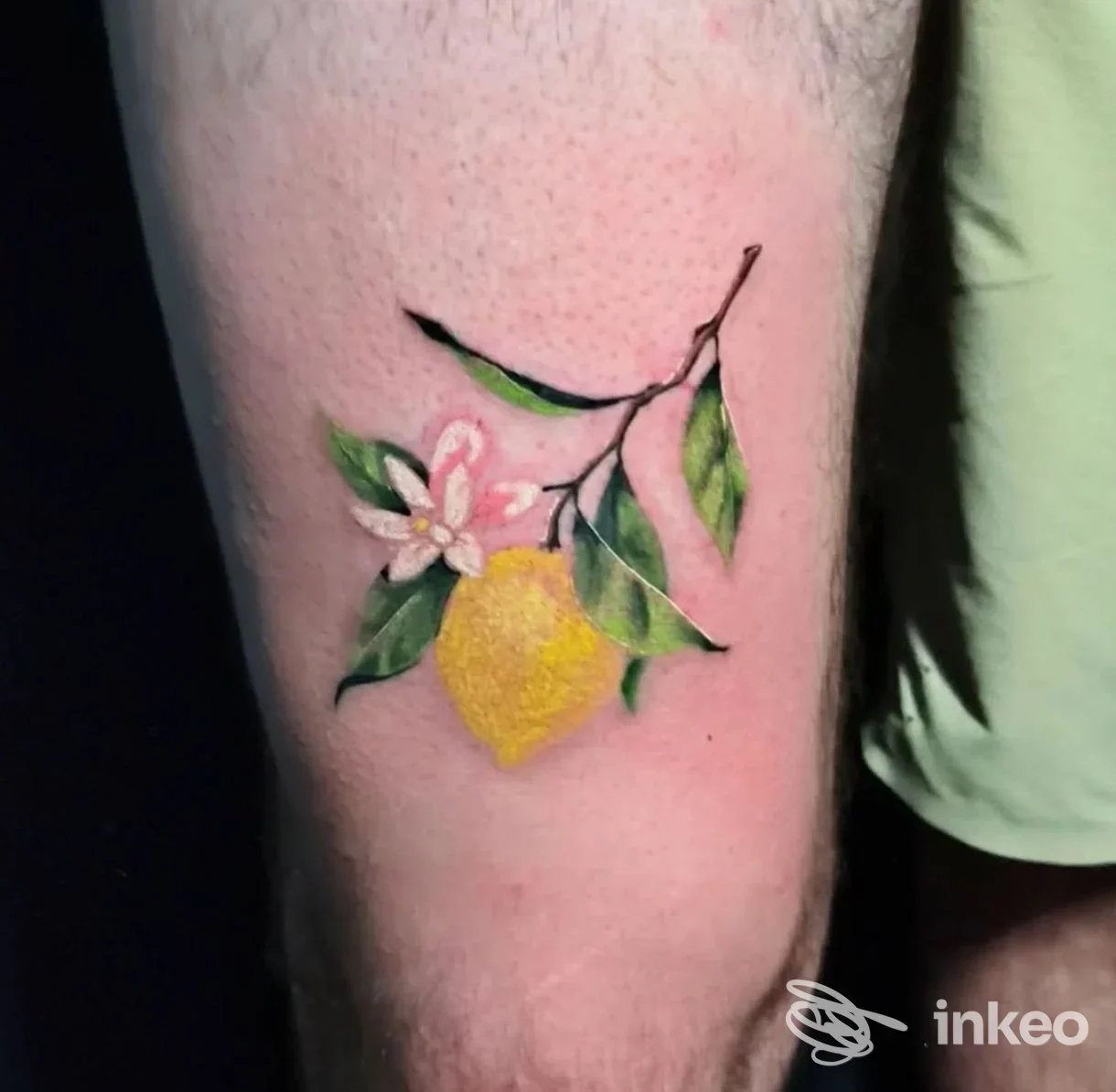 Tatuaggio di un limone con rami, foglie e fiore sulla coscia, Tattoo Skull studio, Catania.