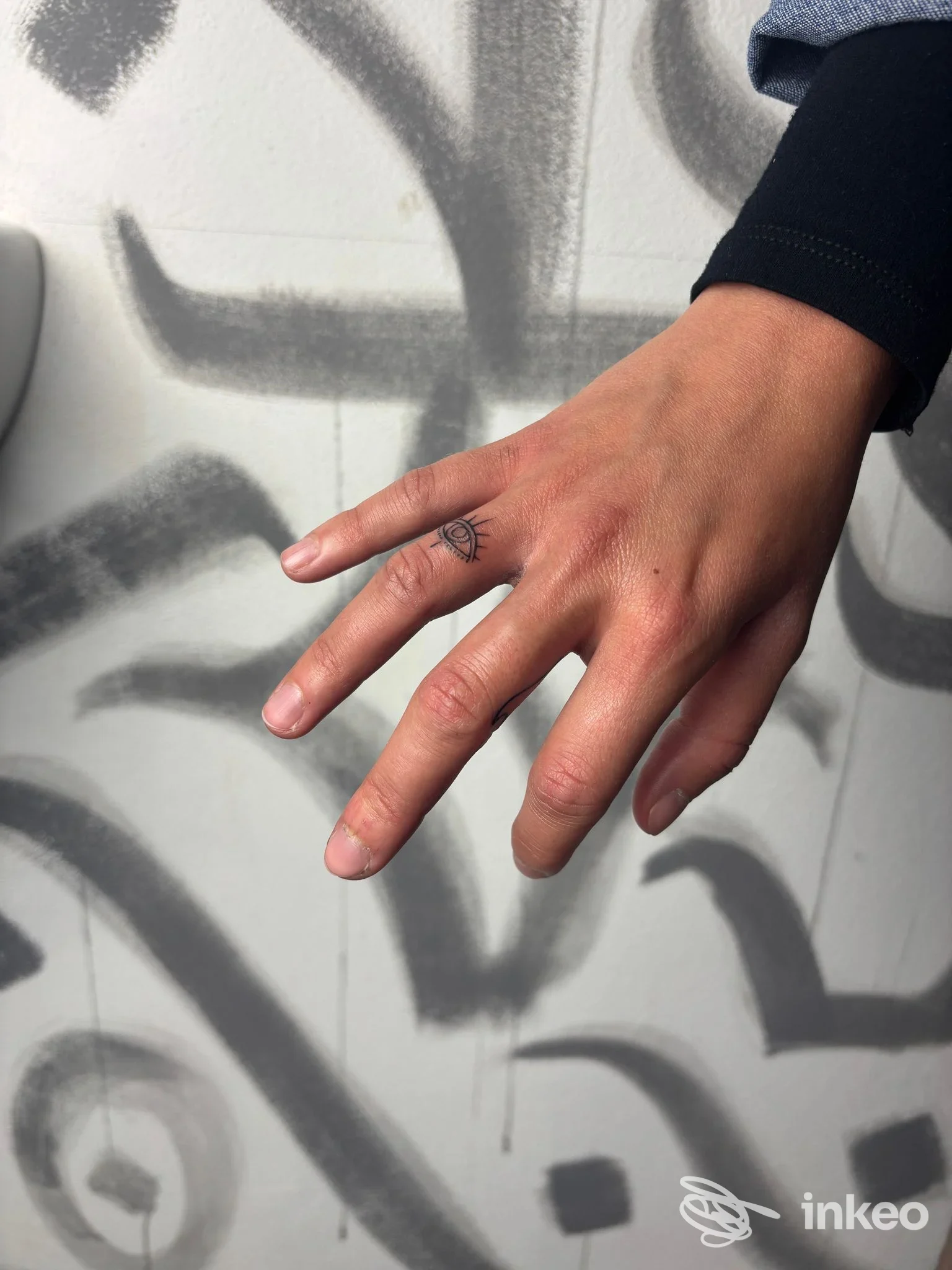 Dettaglio di mano con piccolo tatuaggio minimal sul dito, foto per Space Tattoo Studio a Cecina.