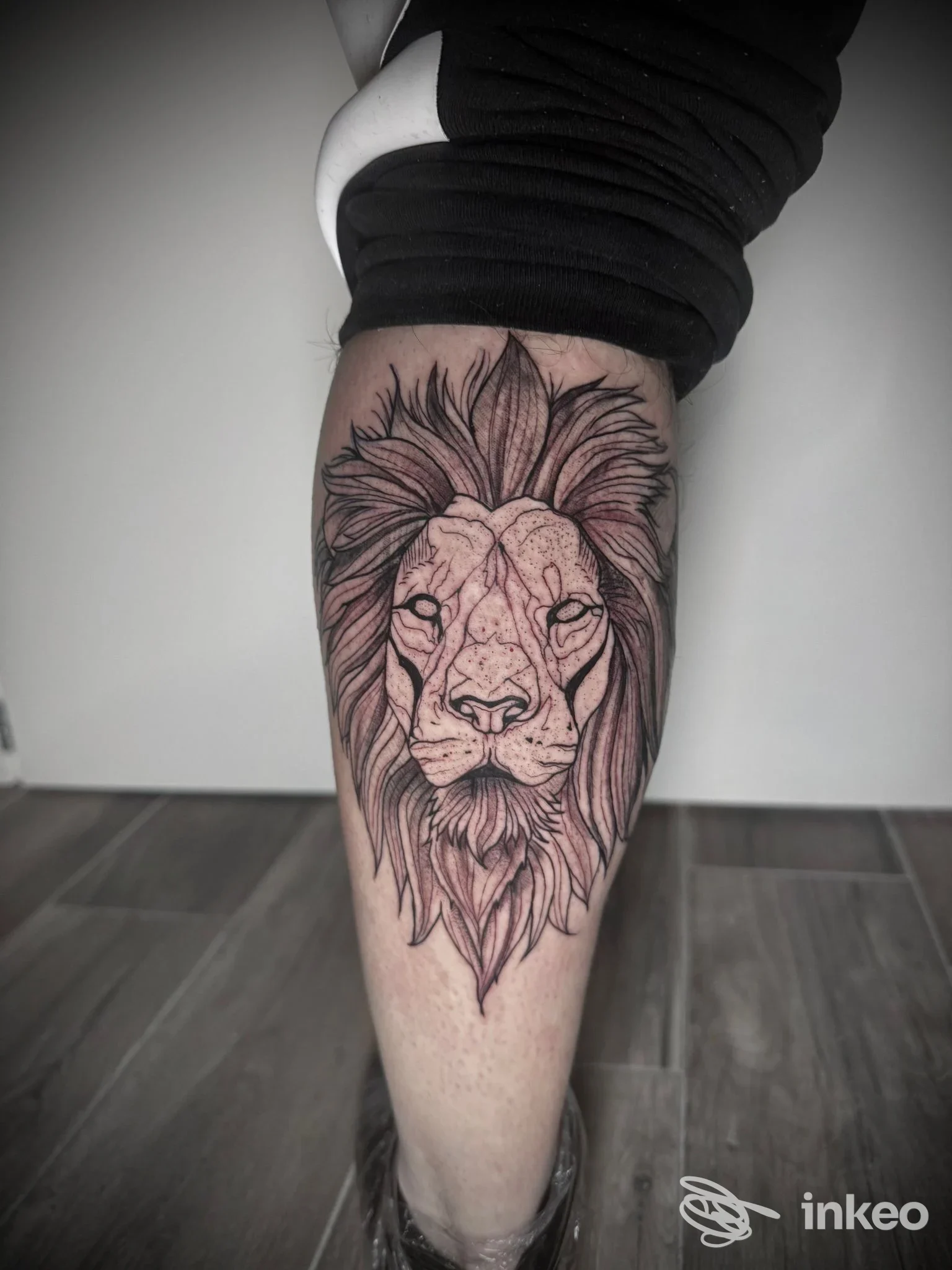 Tatuaggio a inchiostro nero di una testa di leone sul polpaccio, foto realizzata per Infinite Glow Tattoo Studio di Enrica Pallini a Follonica.