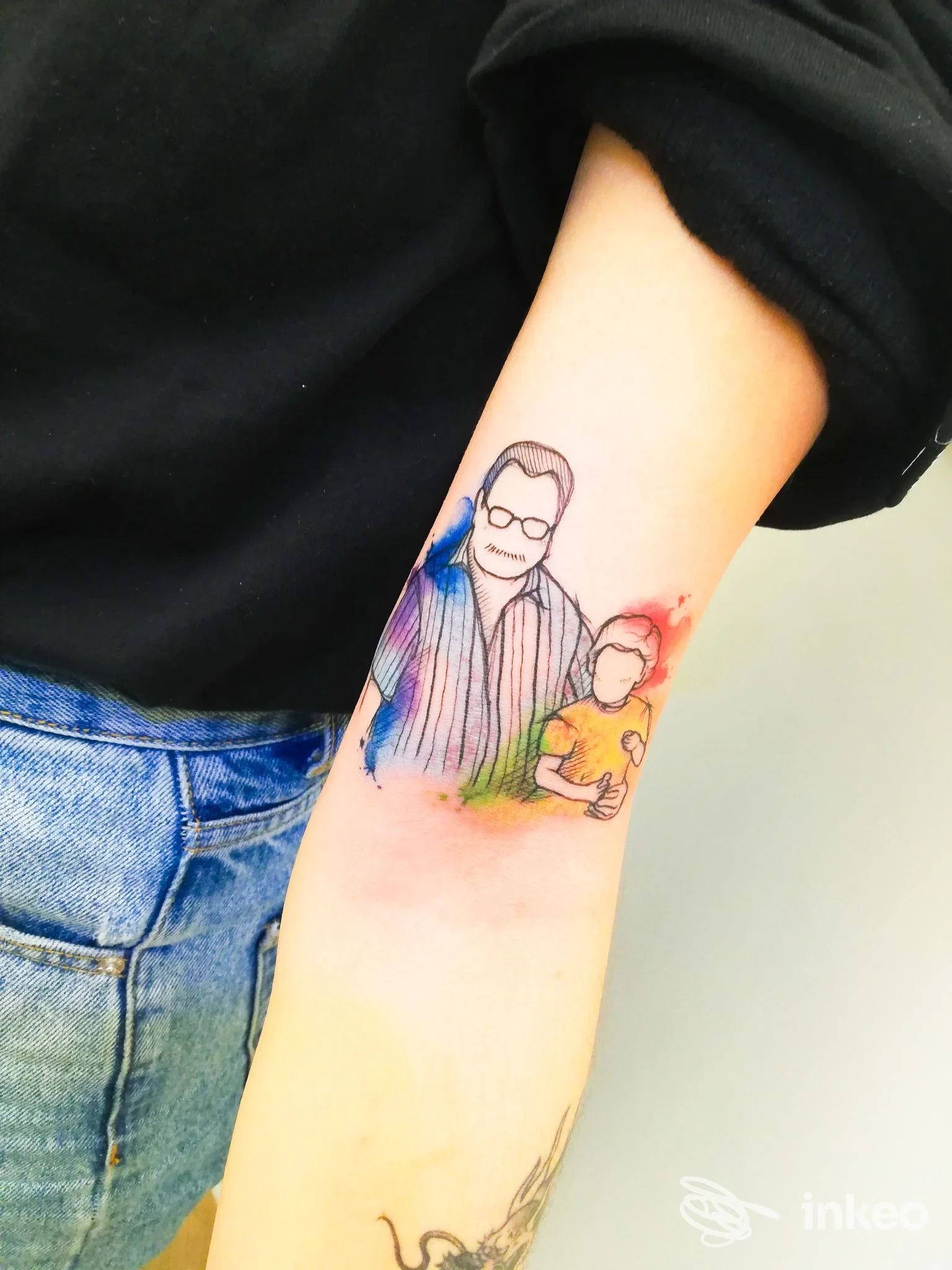 Tatuaggio acquerello su avambraccio interno con due figure stilizzate, foto fornita da Tredici Lune Tattoo Studio, Firenze.