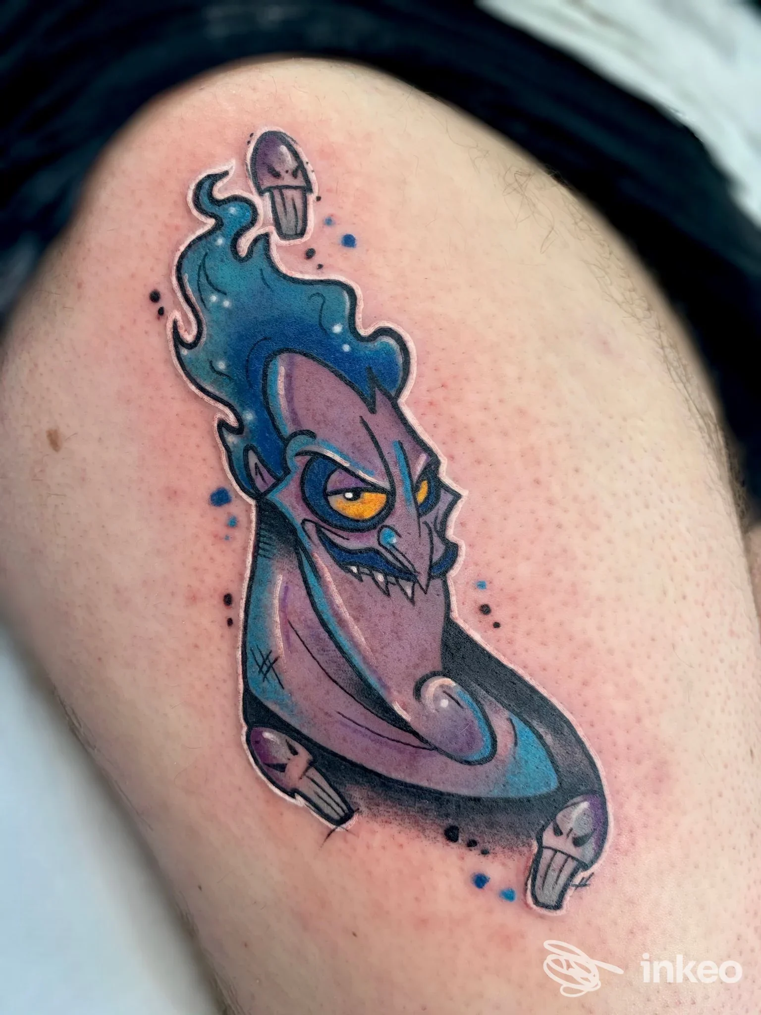 Tatuaggio colorato su coscia raffigurante creatura blu-viola con occhi gialli — Greens Avenue Montevarchi Tattoo & Piercing, Montevarchi.