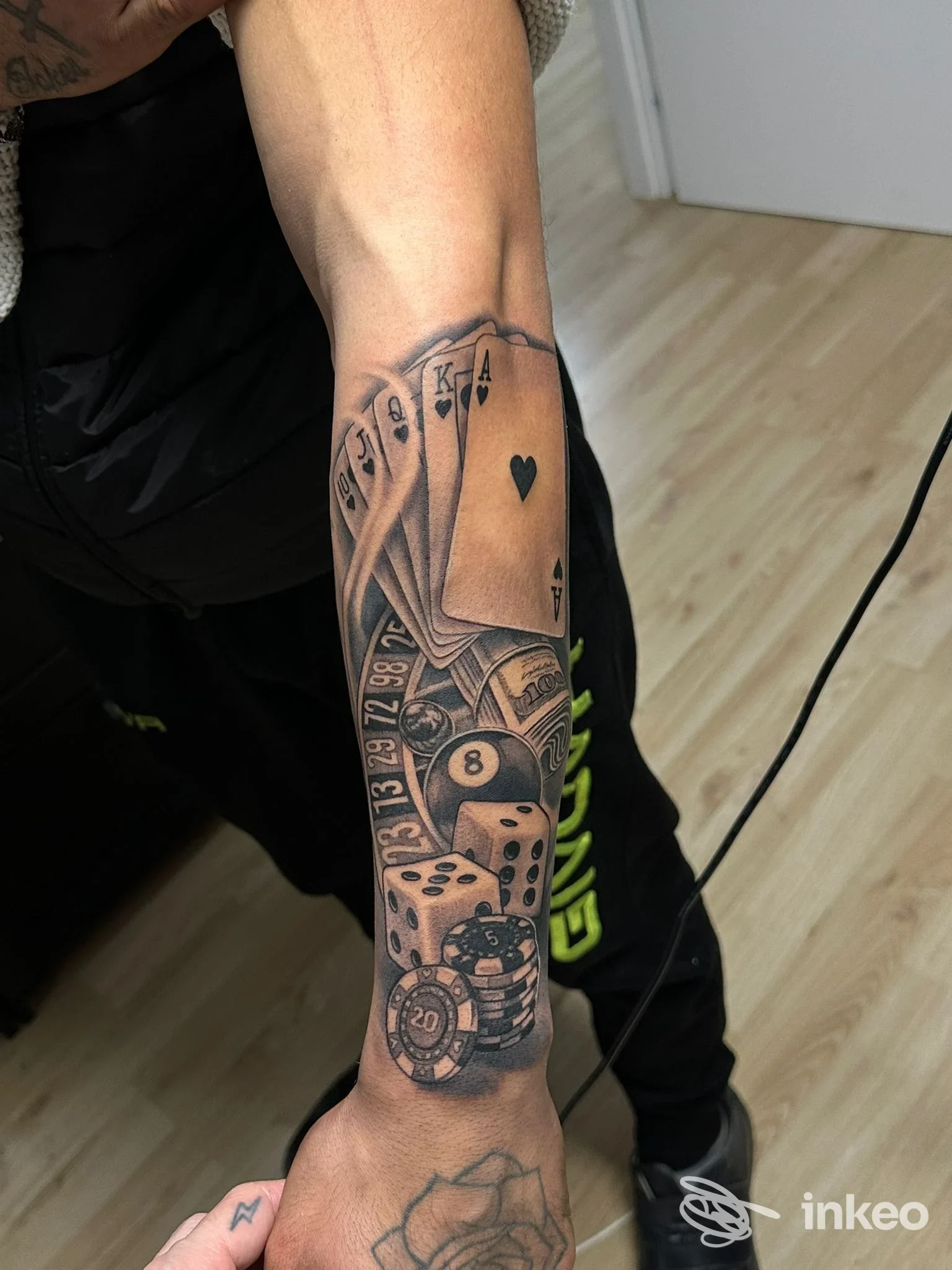 Tatuaggio black & grey su avambraccio con carte, roulette, dadi e gettoni - Matteo Mosca Tattoo Studio, Venezia
