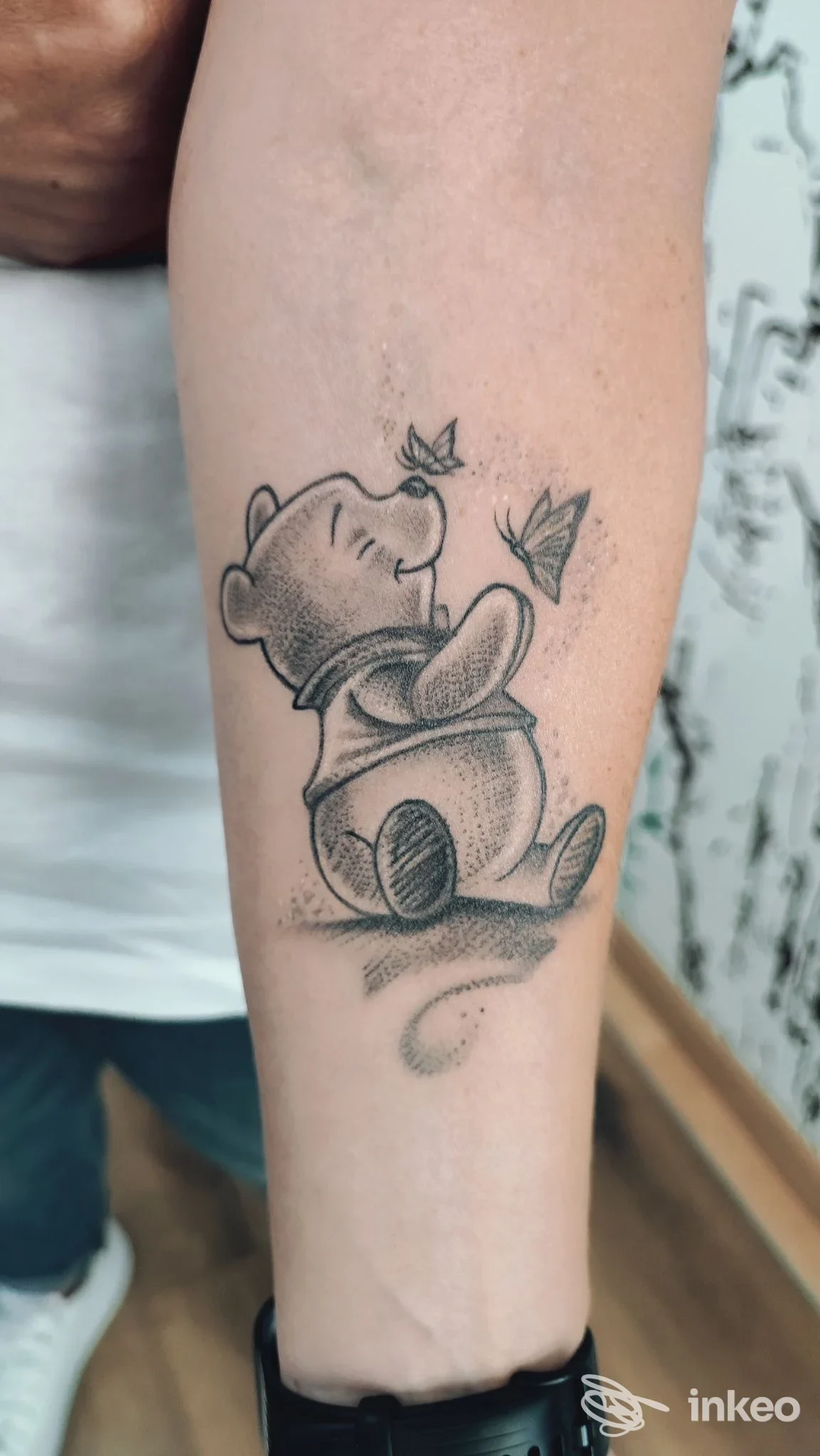 Tatuaggio su avambraccio raffigurante un orsetto seduto con farfalle, PERFECT CRIME TATTOO San Stino di Livenza.