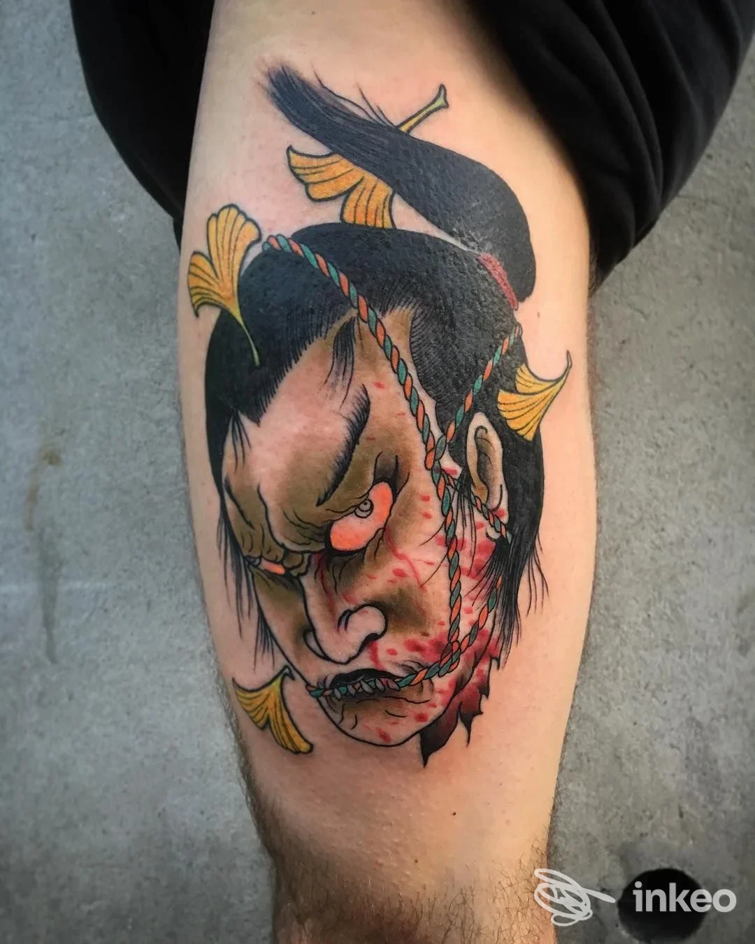 Tatuaggio colorato sul polpaccio raffigurante una maschera in stile giapponese, Mountain Tattoo Studio, Feltre.