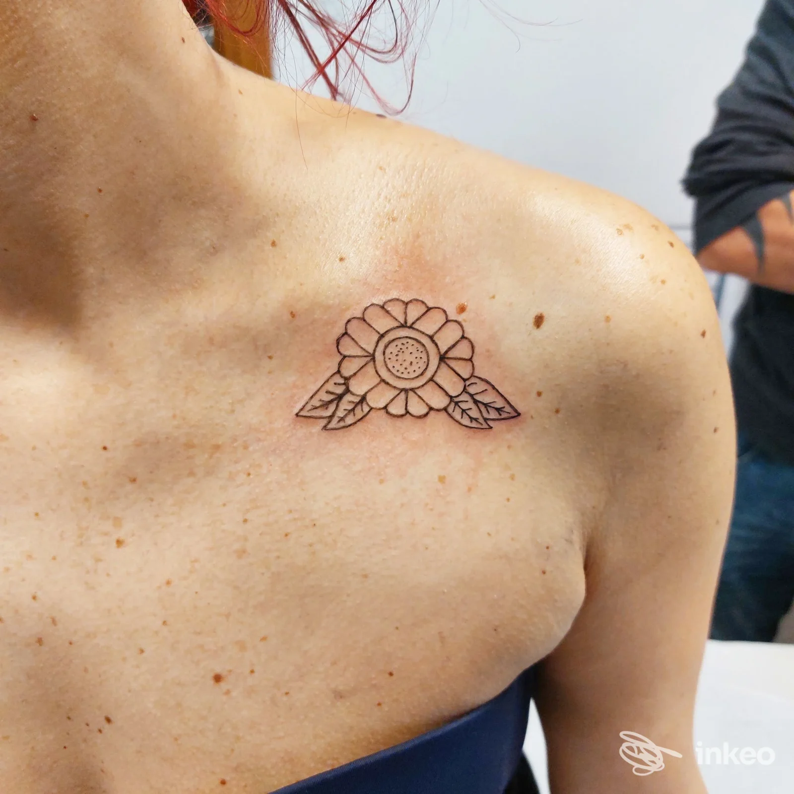 Tatuaggio a inchiostro nero: fiore stilizzato sulla clavicola sinistra, realizzato da Shock Ink Tattoo a Brendola.