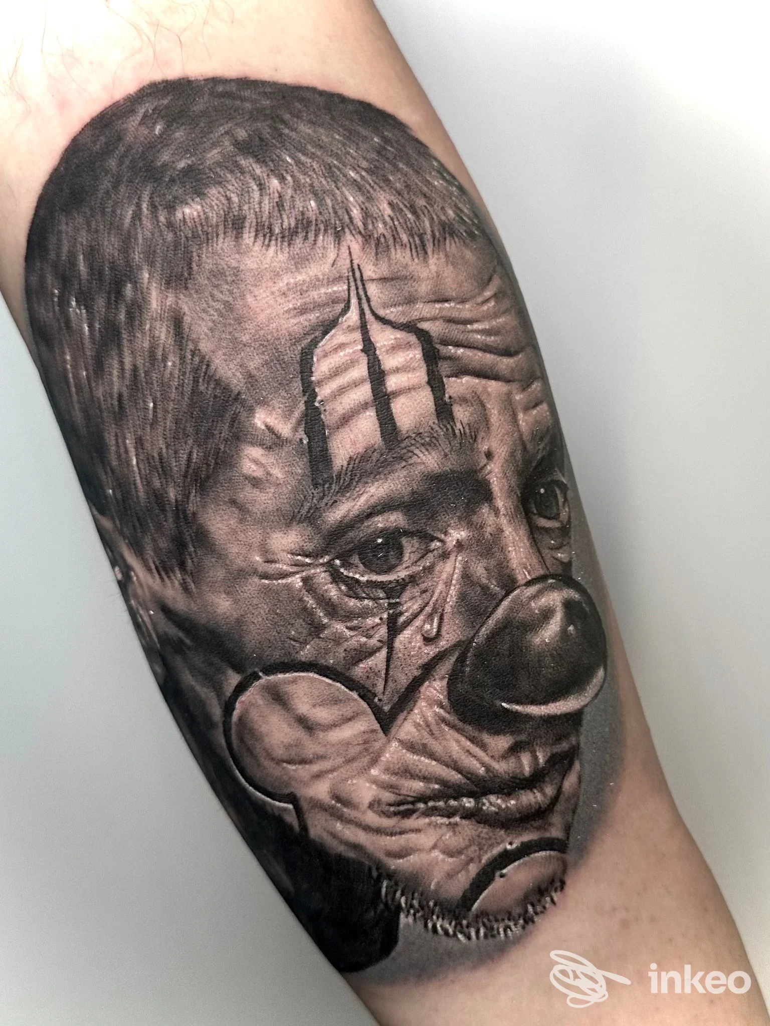 Tatuaggio realistico di un volto da clown sull'avambraccio, opera condivisa da ART INSIDE TATTOO, Civitanova Marche.