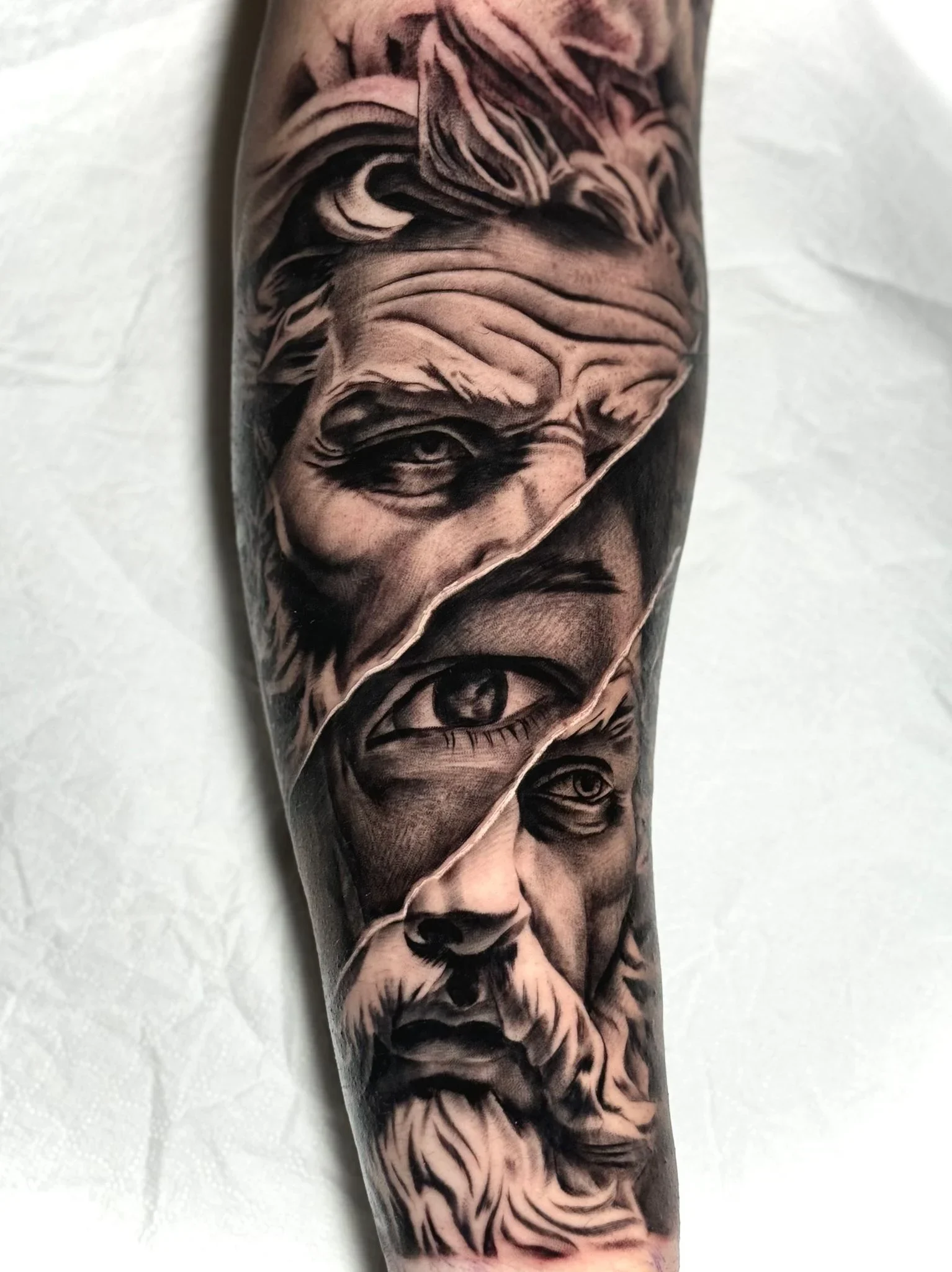 Tatuaggio realistico in bianco e nero su avambraccio con volti sovrapposti, foto fornita da ART INSIDE TATTOO, Civitanova Marche.