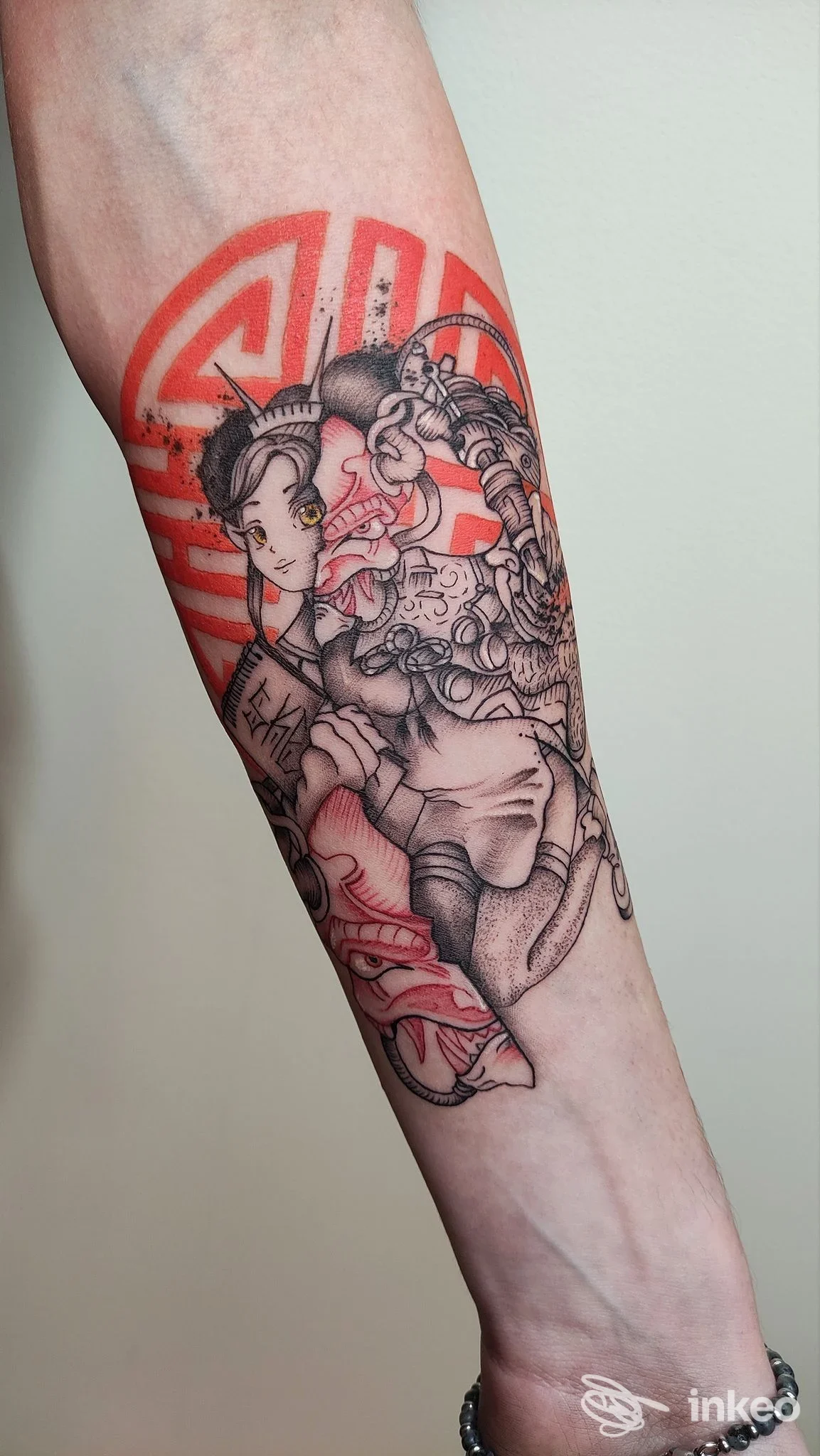 Tatuaggio su avambraccio con figure illustrate e grandi elementi rossi, foto fornita da Akira Tattoo House, Fermo.