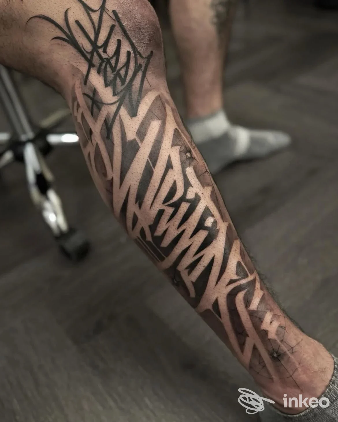 Tatuaggio lettering blackwork che copre il polpaccio, 61121 Tattoo Studio, Pesaro