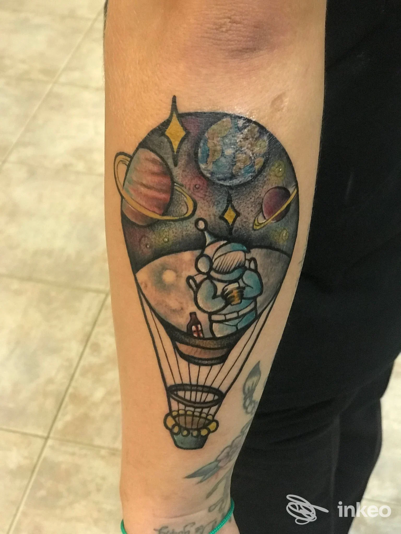 Tatuaggio colorato su avambraccio con mongolfiera spaziale e astronauta, ARTE SUAVE TATTOO SHOP, Pesaro.