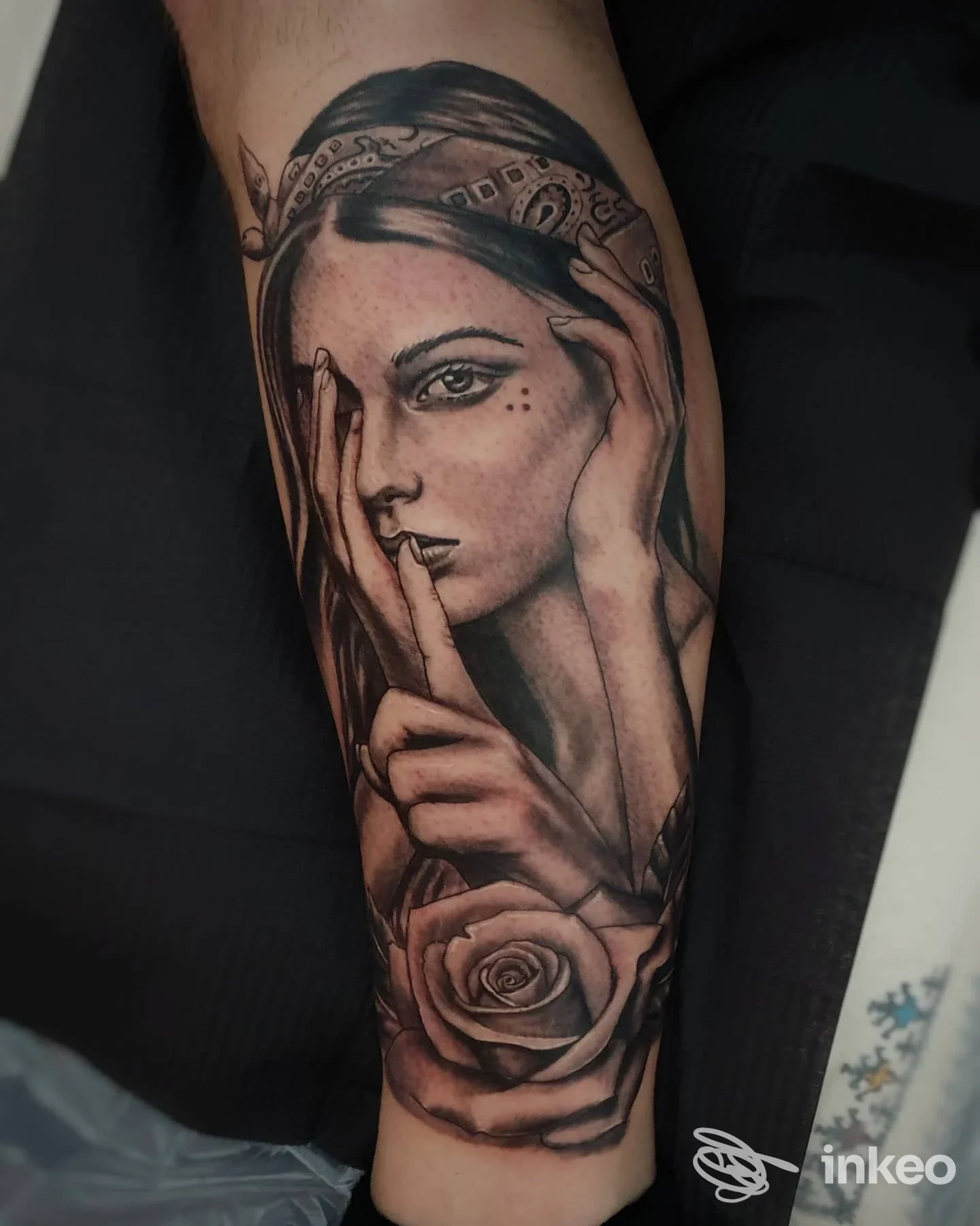 Tatuaggio realistico di volto femminile con mano e rosa sull'avambraccio, realizzato da Classic Tattoo a San Benedetto del Tronto.