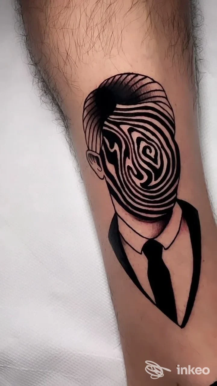 Tatuaggio blackwork su avambraccio raffigurante figura in giacca e cravatta con volto a linee concentriche, Bloom tattoo studio, Porto Sant'Elpidio.