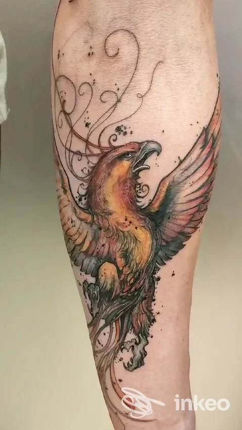 Tatuaggio colorato a forma di uccello con ali spiegate sull'avambraccio, foto fornita da Crazy Horse Tattoo Studio, Falconara Marittima.