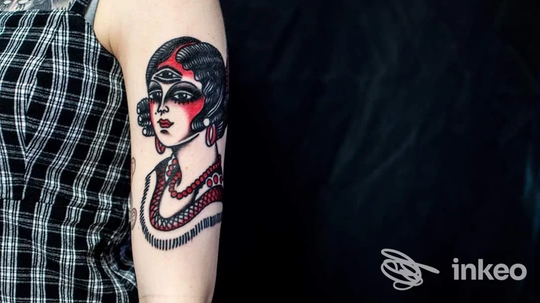 Tatuaggio a colori su avambraccio che raffigura un volto stilizzato; immagine fornita da Cry Baby Tattoo Shop, Porto Potenza Picena.
