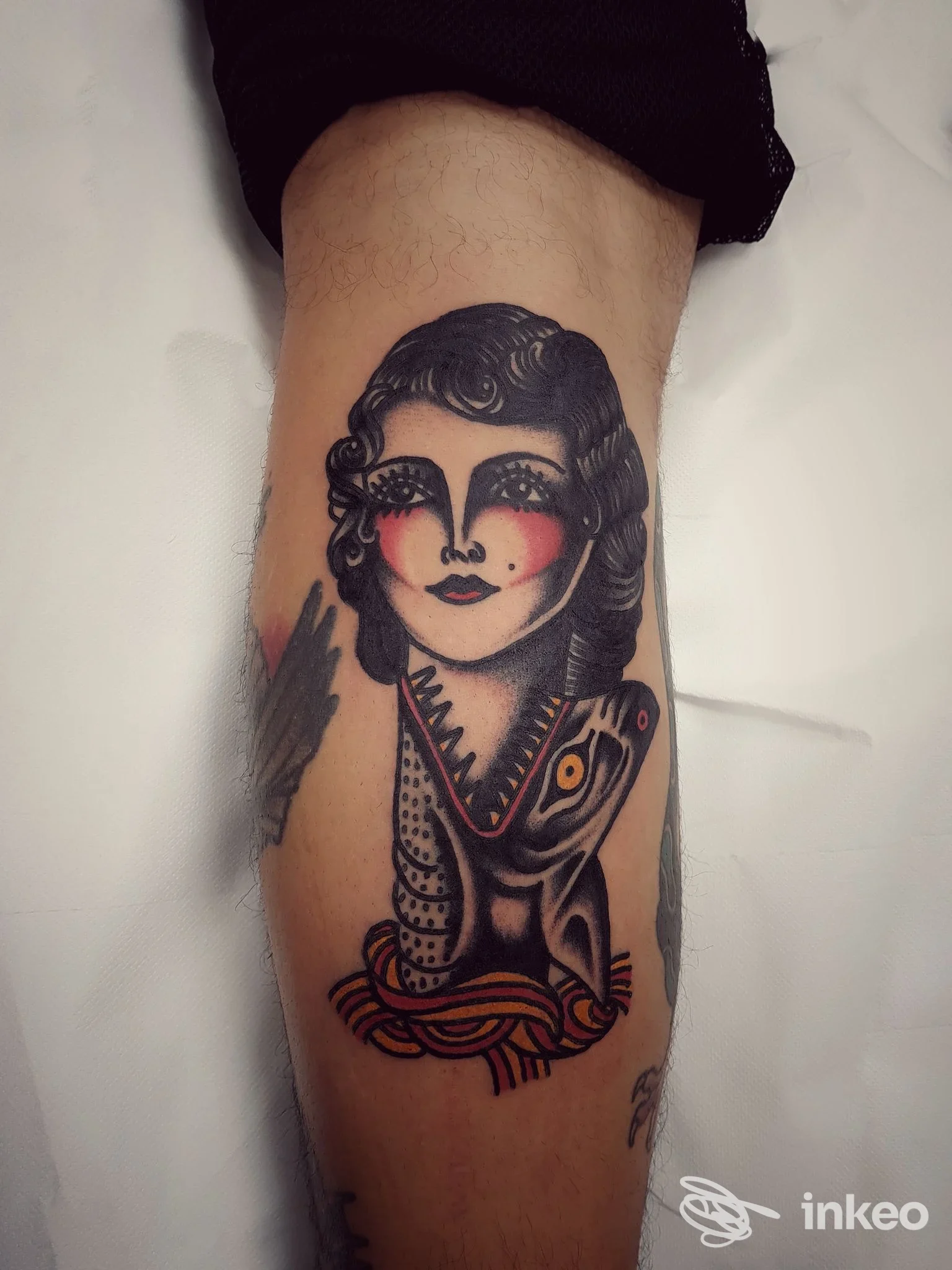 Tatuaggio su polpaccio con volto femminile stilizzato e motivo animale, Cry Baby Tattoo Shop a Porto Potenza Picena.