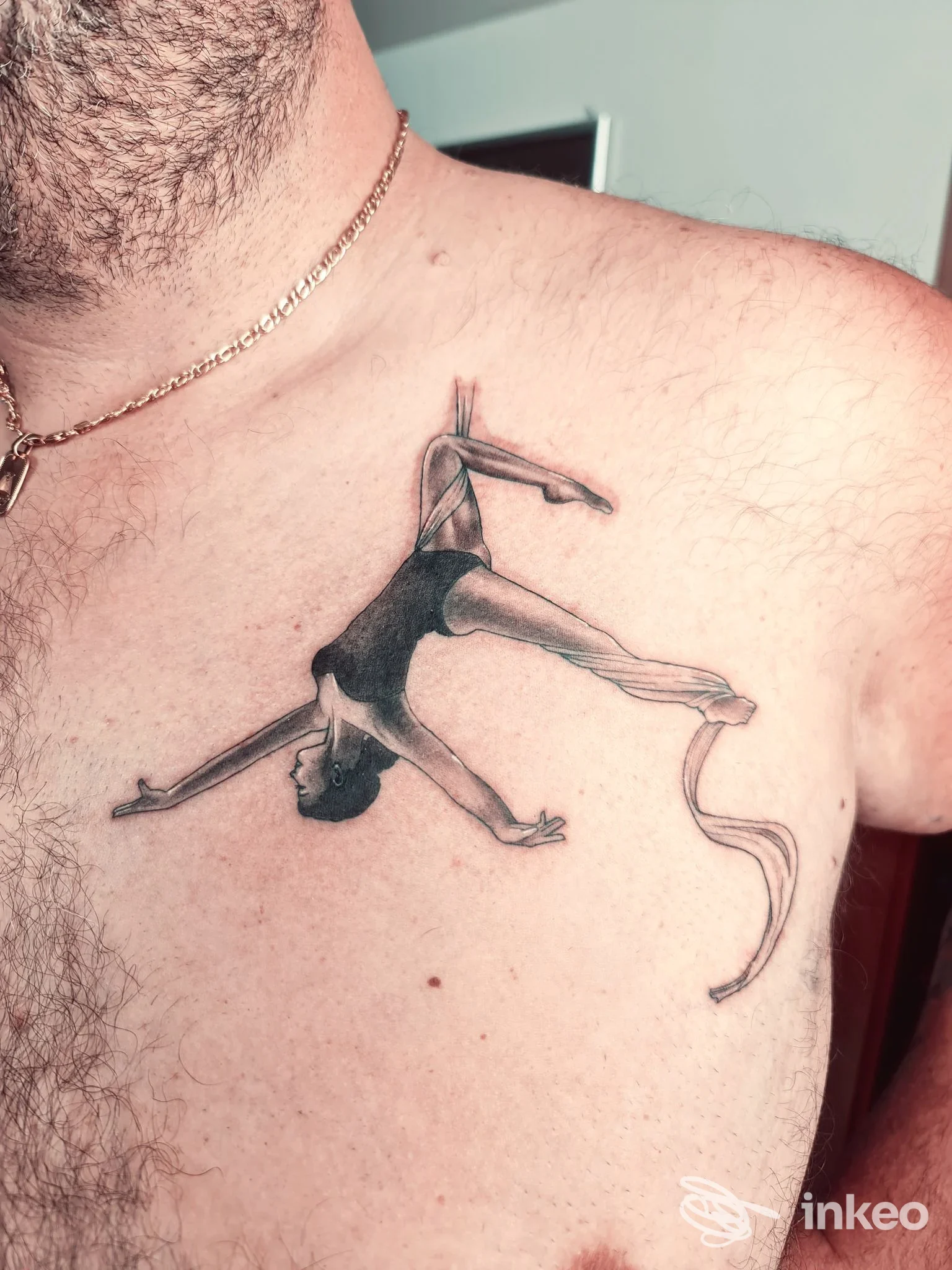 Primo piano del petto con tatuaggio raffigurante una figura acrobatica, eseguito da DIABOLINK tattoo&piercing a Petritoli.