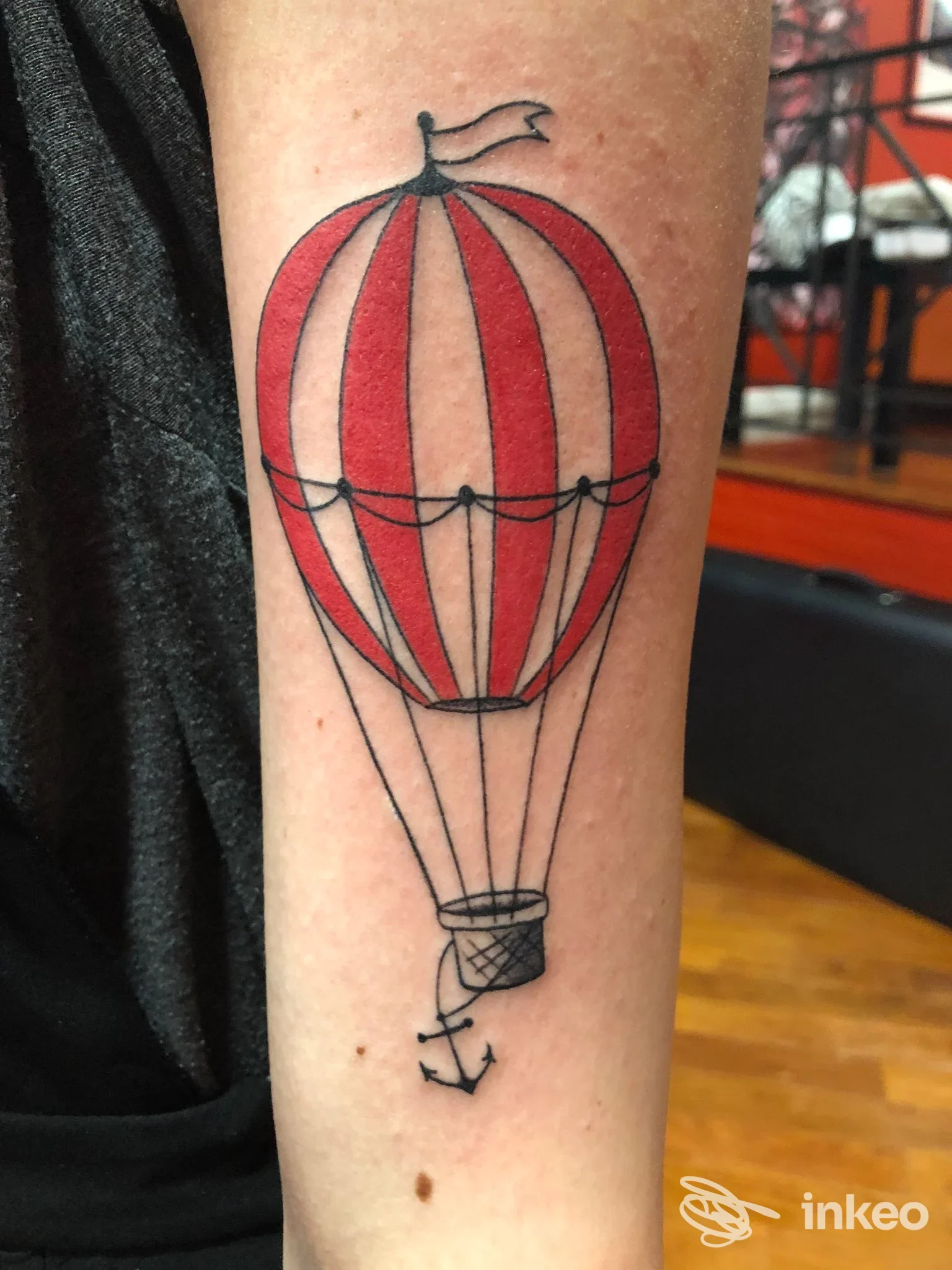 Tatuaggio su avambraccio di una mongolfiera rossa e bianca, Charro’s Tattoo Art Club a Porto Potenza Picena.