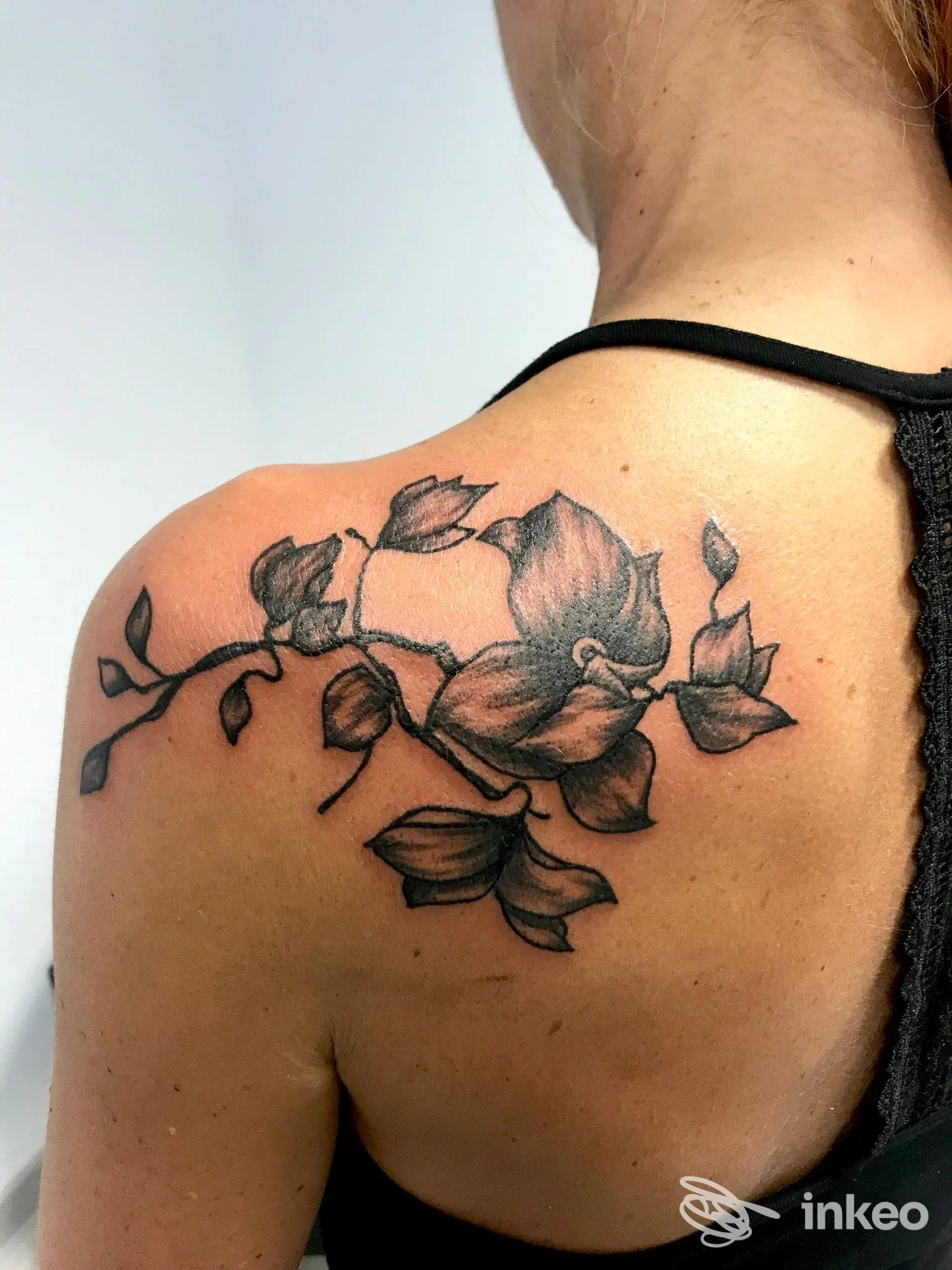 Tatuaggio floreale nero sulla scapola destra, fotografato in primo piano; eseguito da Doodle Tattoo Studio a Borgo Massano.