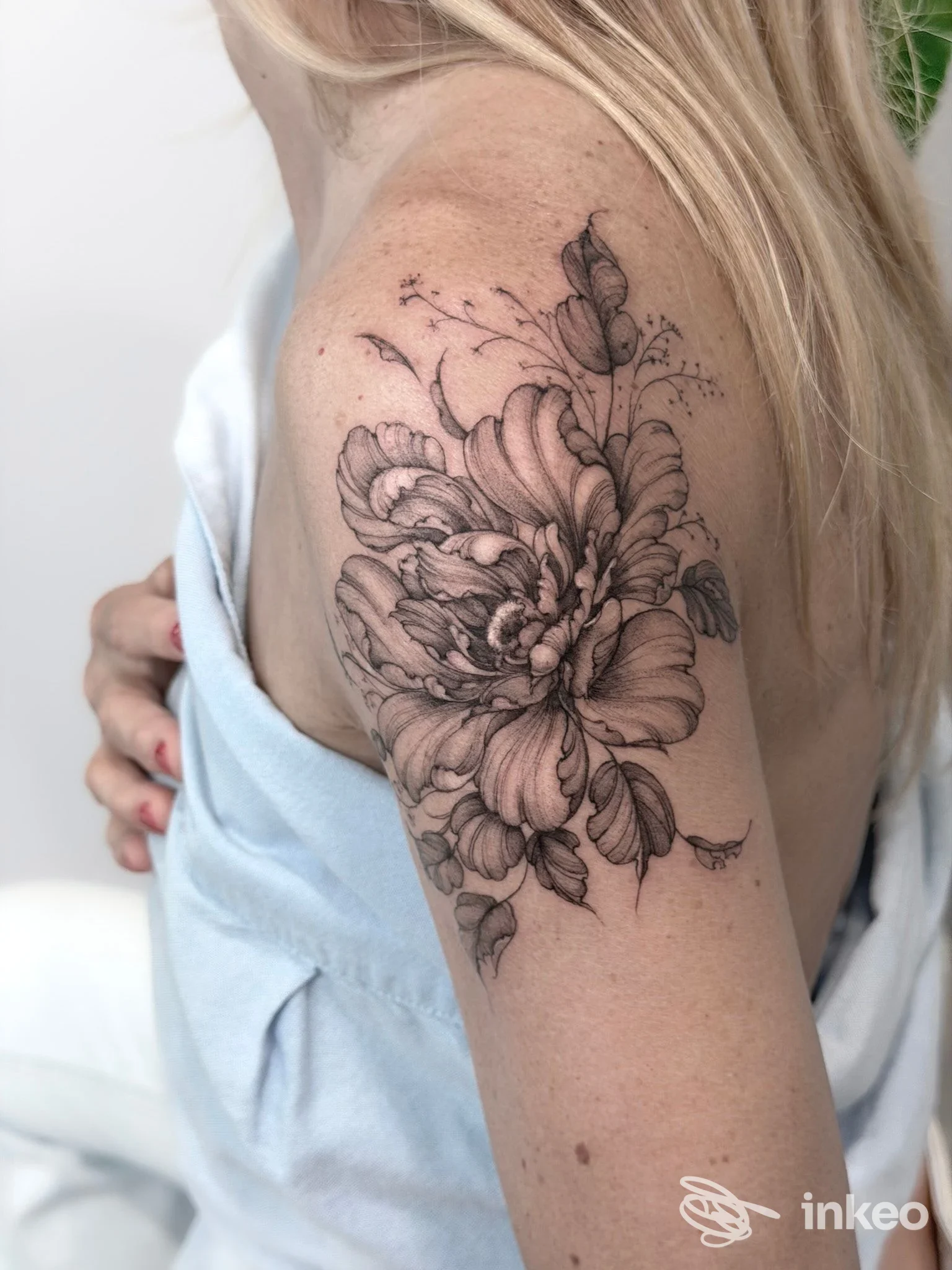 Foto di un grande tatuaggio floreale in nero e grigio sul deltoide di una donna, realizzato da Eggwhite tattoo studio a San Benedetto del Tronto.