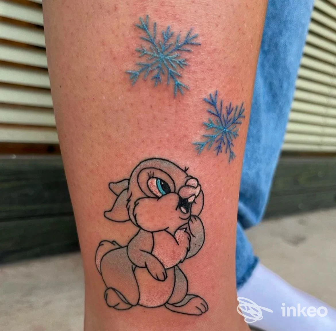 Tatuaggio su polpaccio con personaggio in stile cartone e due fiocchi di neve, Homeward Tattoo Senigallia, Senigallia.