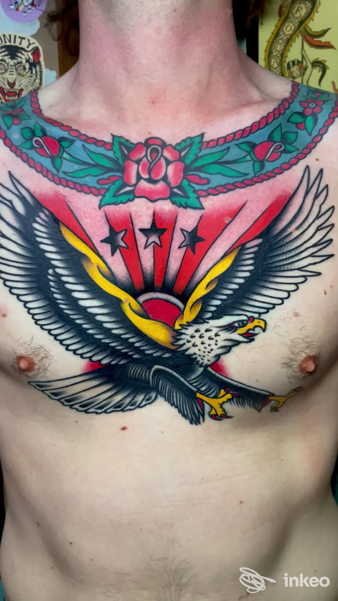 Ampio tatuaggio tradizionale su petto e collo con un'aquila centrale e un collare floreale — Homeward Tattoo, Senigallia.