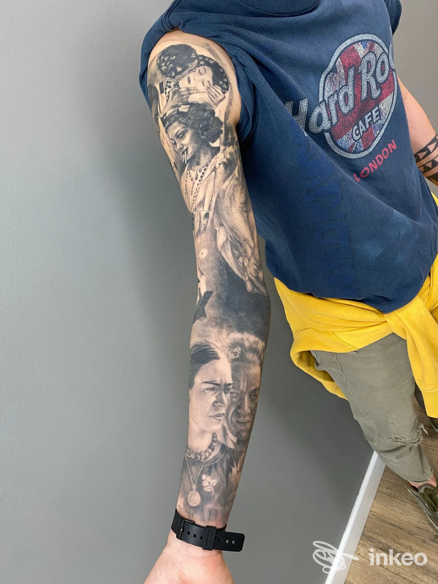 Manica tatuata in bianco e nero sul braccio sinistro, ritratti realistici eseguiti da Ink River Artigiani Tatuatori a Pesaro.