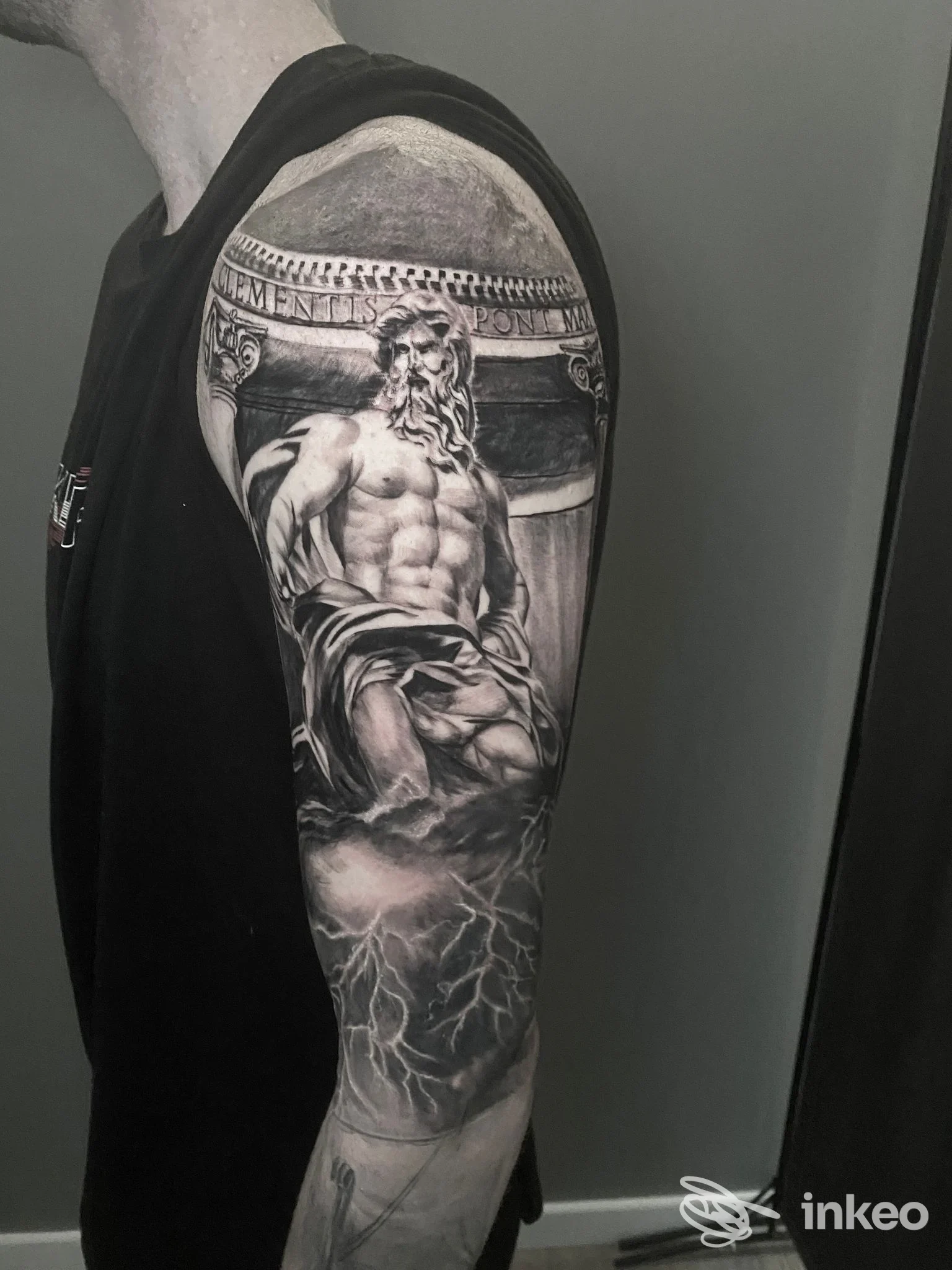 Tatuaggio realistico in bianco e nero a manica sul braccio, scena mitologica; foto per Ink River Artigiani Tatuatori, Pesaro.