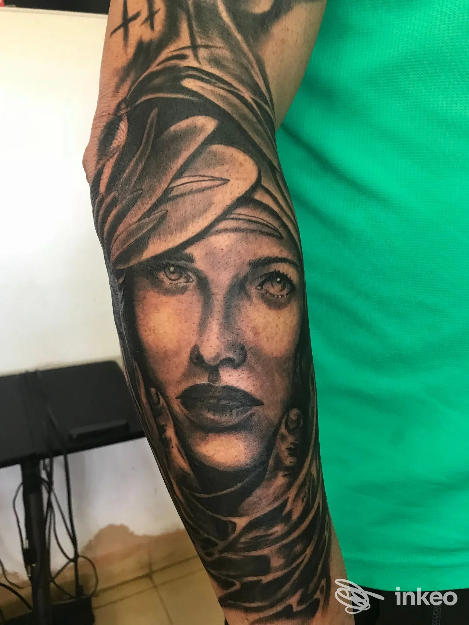 Tattoo realistico di una donna sul braccio, con tonalità scure e dettagli di ombreggiatura; nessun overlay o elemento esterno visibile.