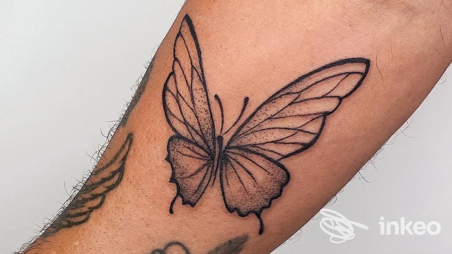Tatuaggio a forma di farfalla in nero su avambraccio, fotografia dello studio Gloria Tattoo a Camerino.