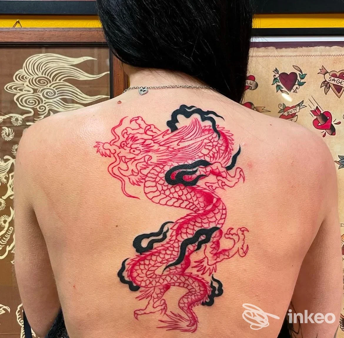 Grande tatuaggio di drago rosso e nero sulla schiena di una cliente, foto scattata nello studio Homeward Tattoo a Jesi.