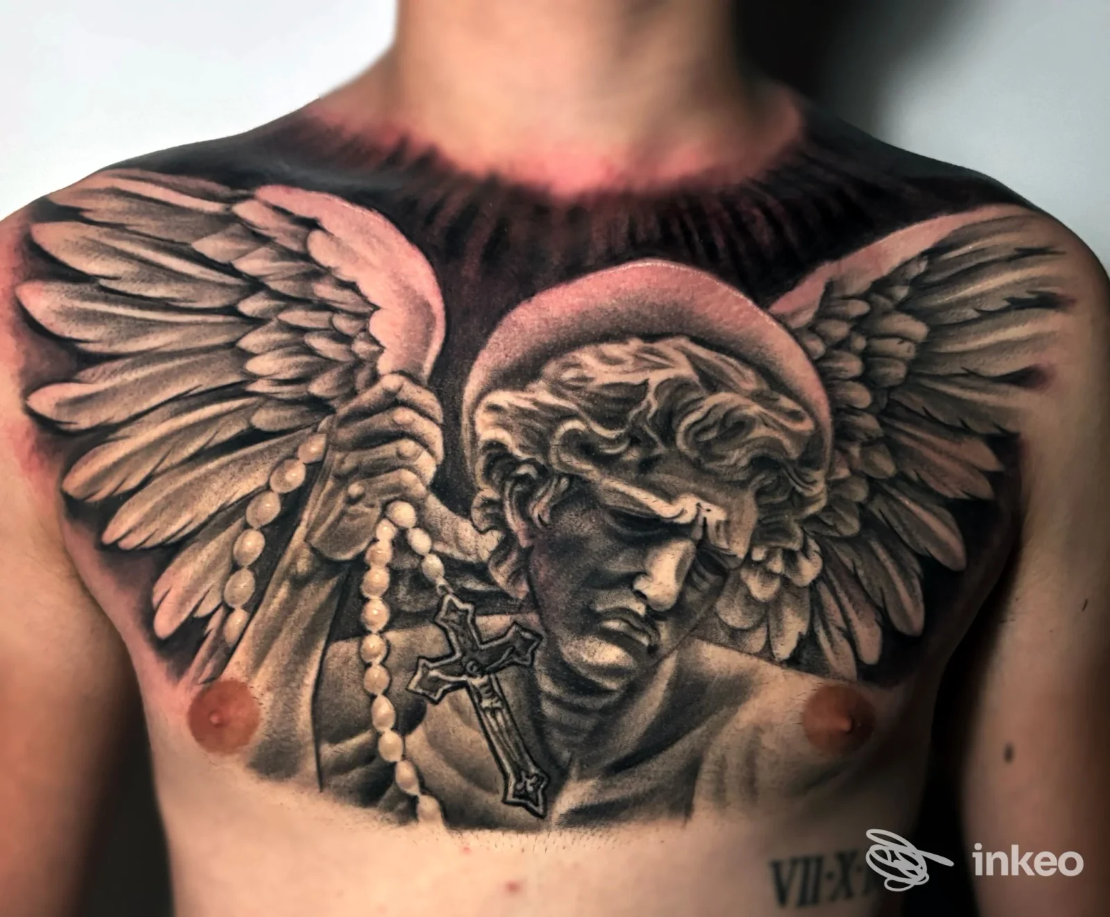 Ampio tatuaggio black & grey su petto raffigurante un angelo con ali e rosario — Ink City Tattoo SBT, San Benedetto del Tronto.