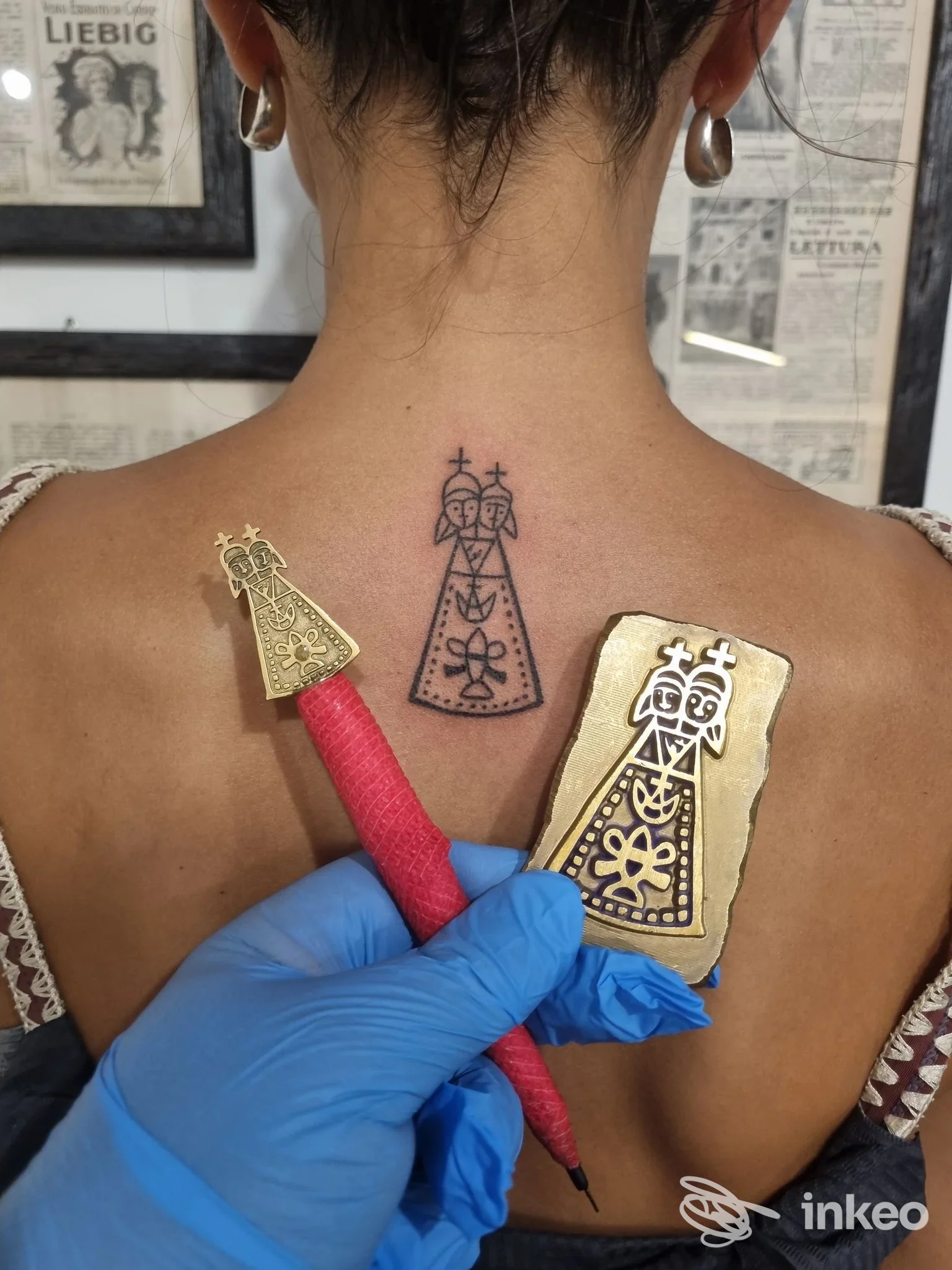 Tatuaggio nero stilizzato sulla parte superiore della schiena, vicino alla base del collo; foto dello studio Jona Tatuaggi Lauretani, Loreto.