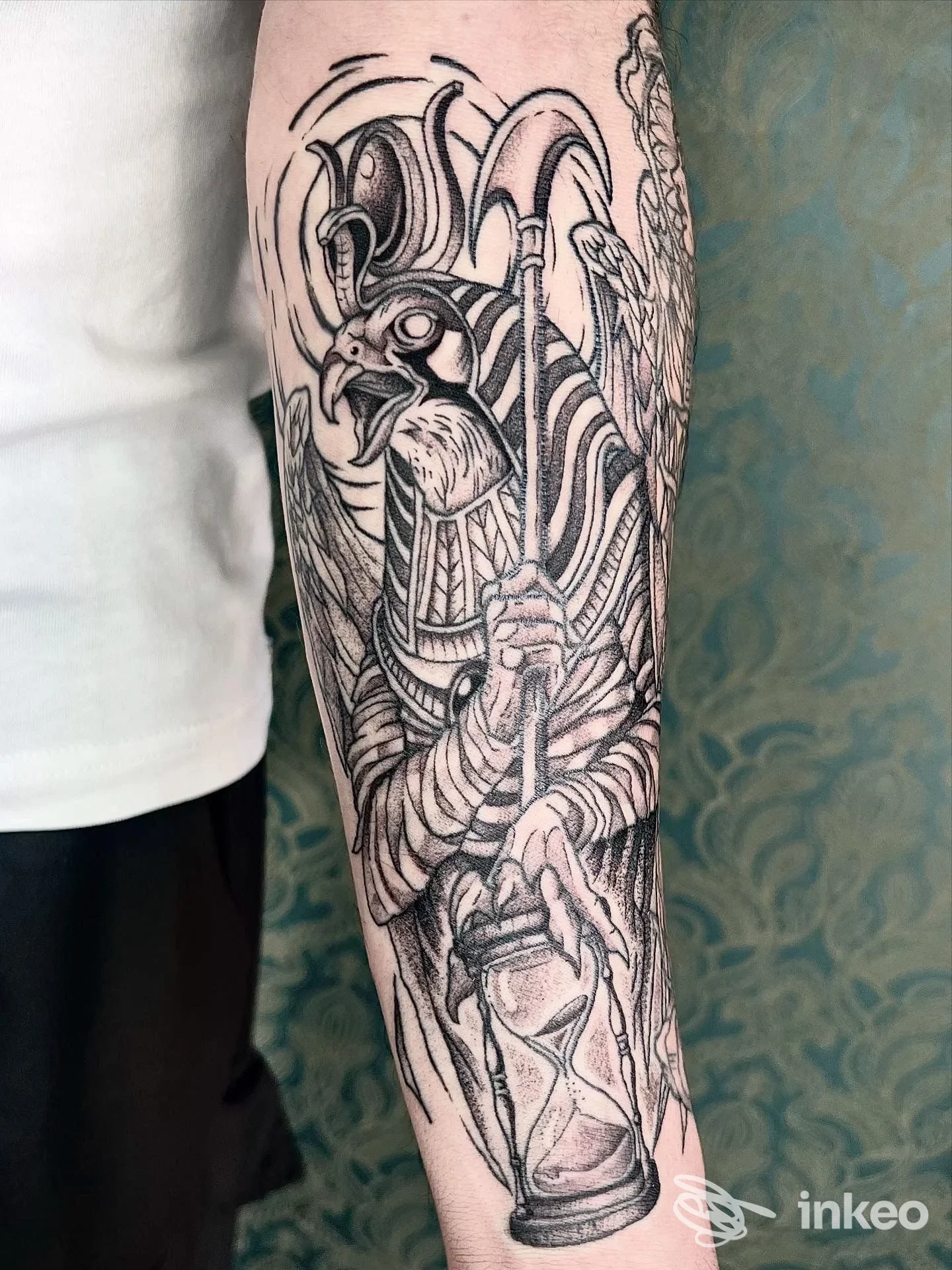 Avambraccio tatuato con figura con testa di rapace e clessidra, foto del lavoro eseguito da Kali Tattoo Studio a San Benedetto del Tronto.