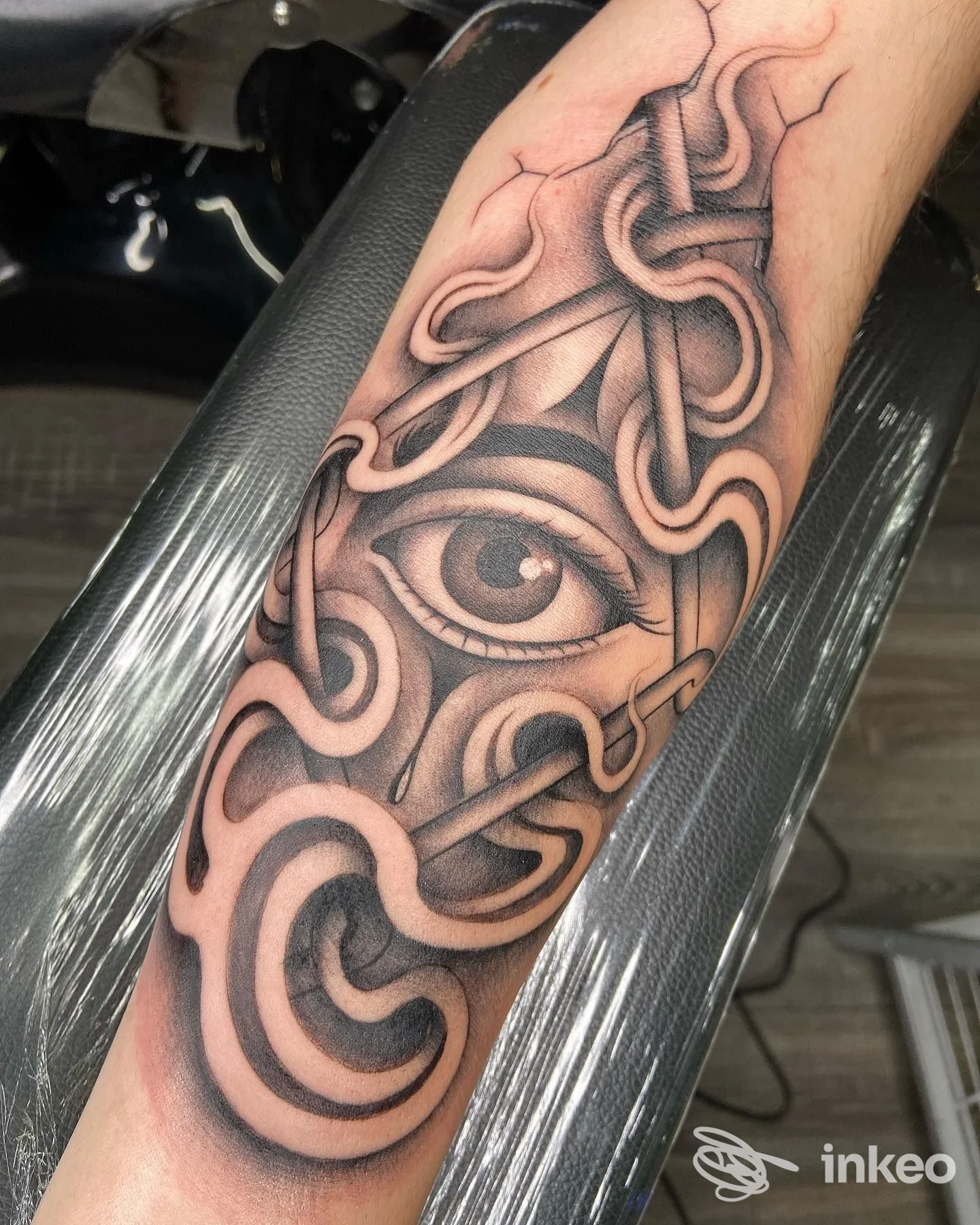 Tatuaggio in bianco e nero sull'avambraccio con occhio stilizzato e motivi dotwork, realizzato da Magical Ink Tattoo a Fabriano.