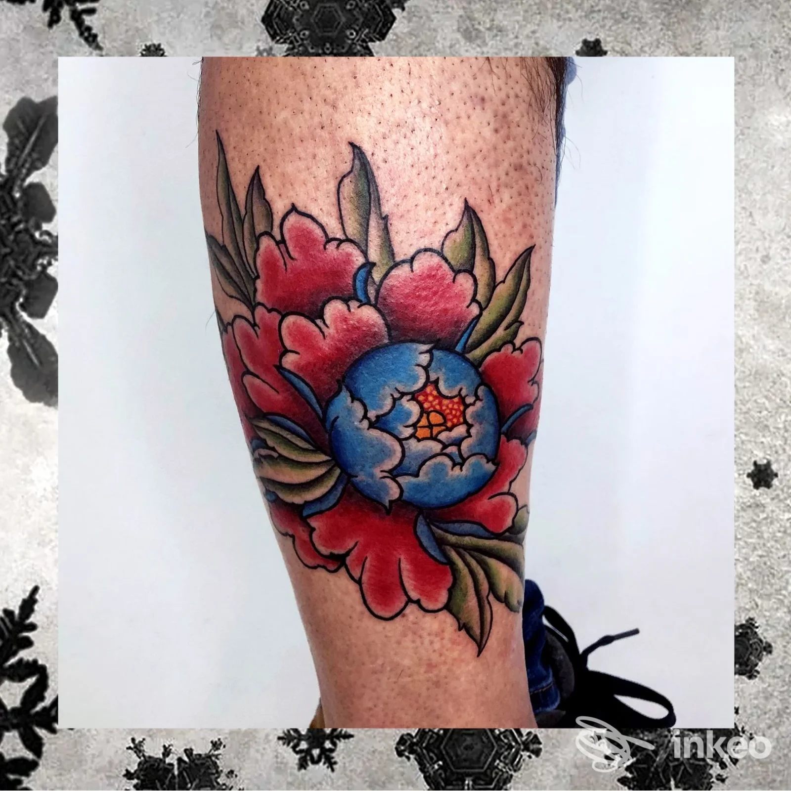 Tatuaggio floreale a colori sul polpaccio, eseguito da Malasorte Tattoo Studio a Porto Sant'Elpidio, linee nette e riempimenti pieni.