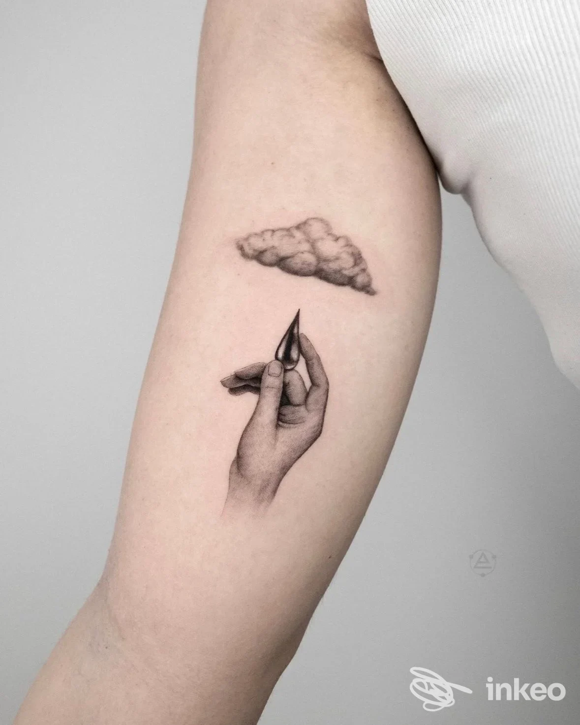 Tatuaggio realistico su avambraccio interno con mano stilizzata che tiene un ago e una piccola nuvola sopra, Marte tattoo planet, Tolentino.