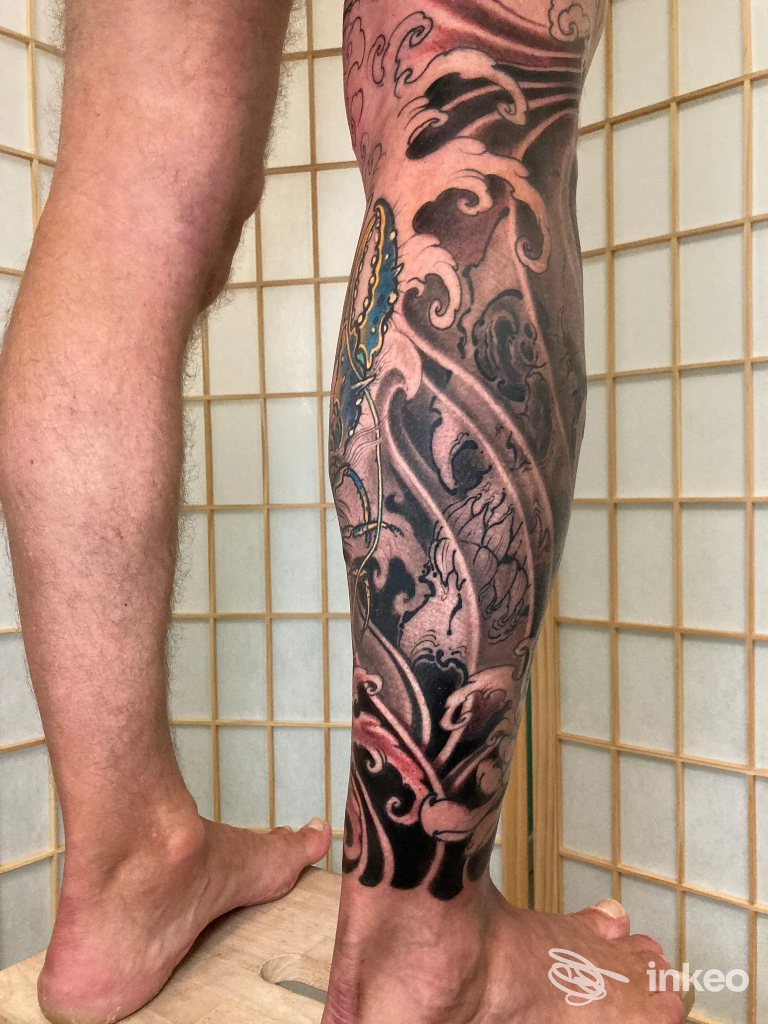 Polpaccio tatuato con motivi scuri e dettagli colorati, foto inviata da Newen Tattoo Studio ad Ancona.