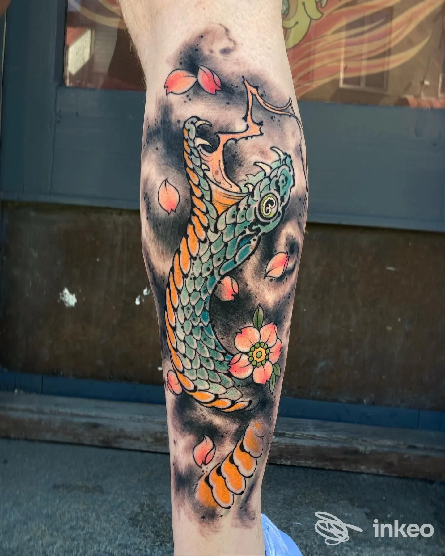 Tatuaggio colorato a tema squamato con fiori sull'avambraccio, fotografato da Newen Tattoo Studio ad Ancona.