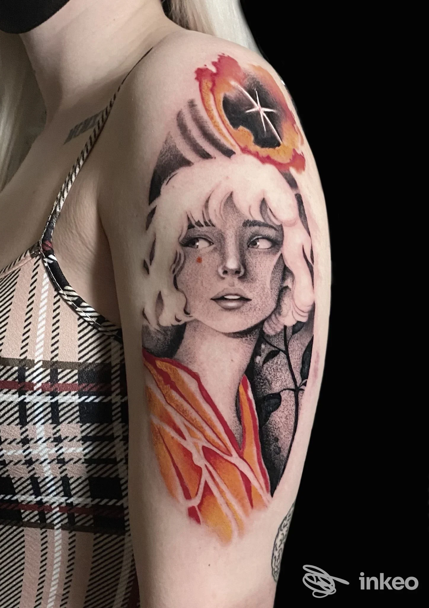 Tatuaggio a mezza manica su braccio superiore con volto stilizzato e dettagli arancioni, Ossidiana Tattoo studio, Colmurano.